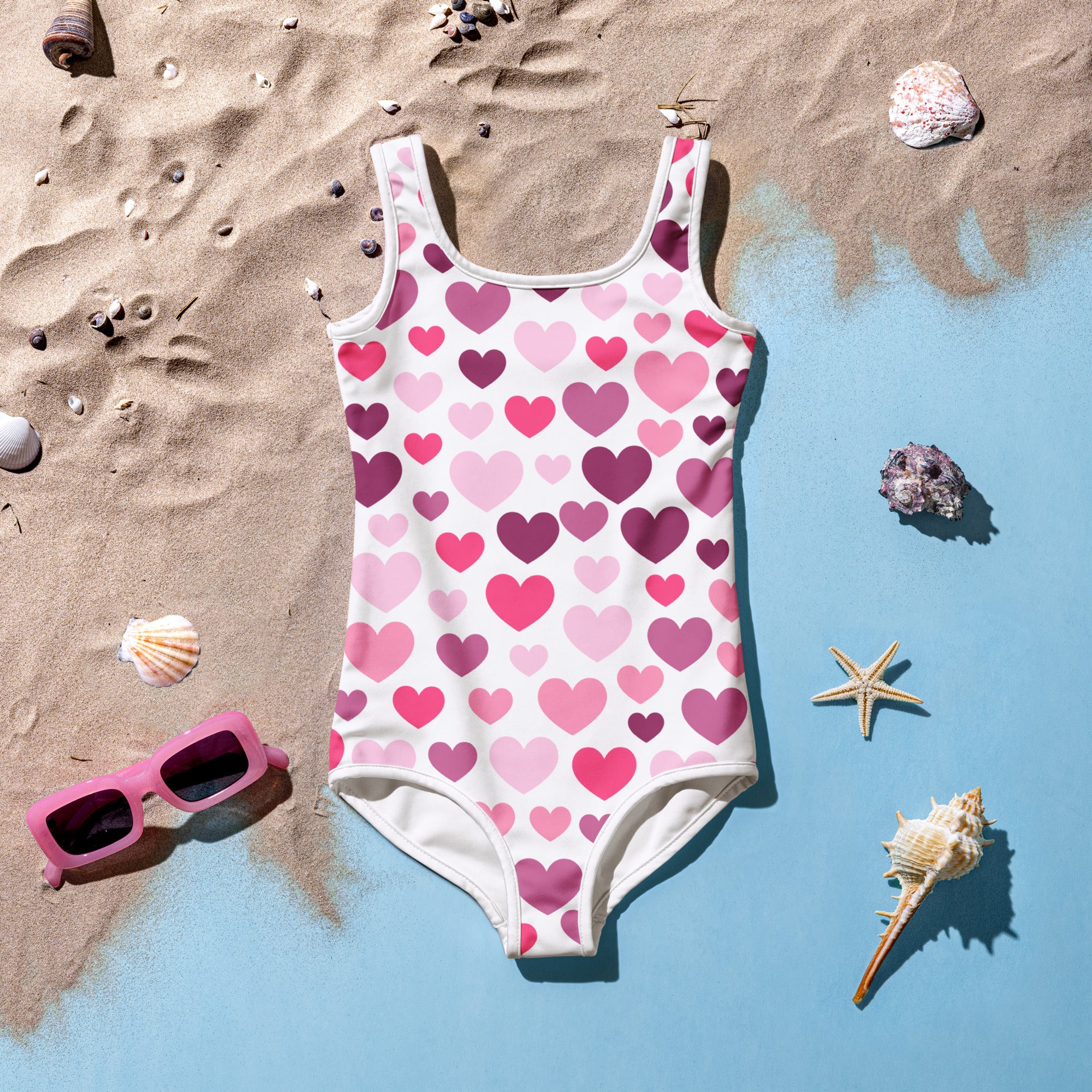 A white one-piece girls swimsuit with pink and purple hearts buttery soft with UPF 50 plus and double layered front