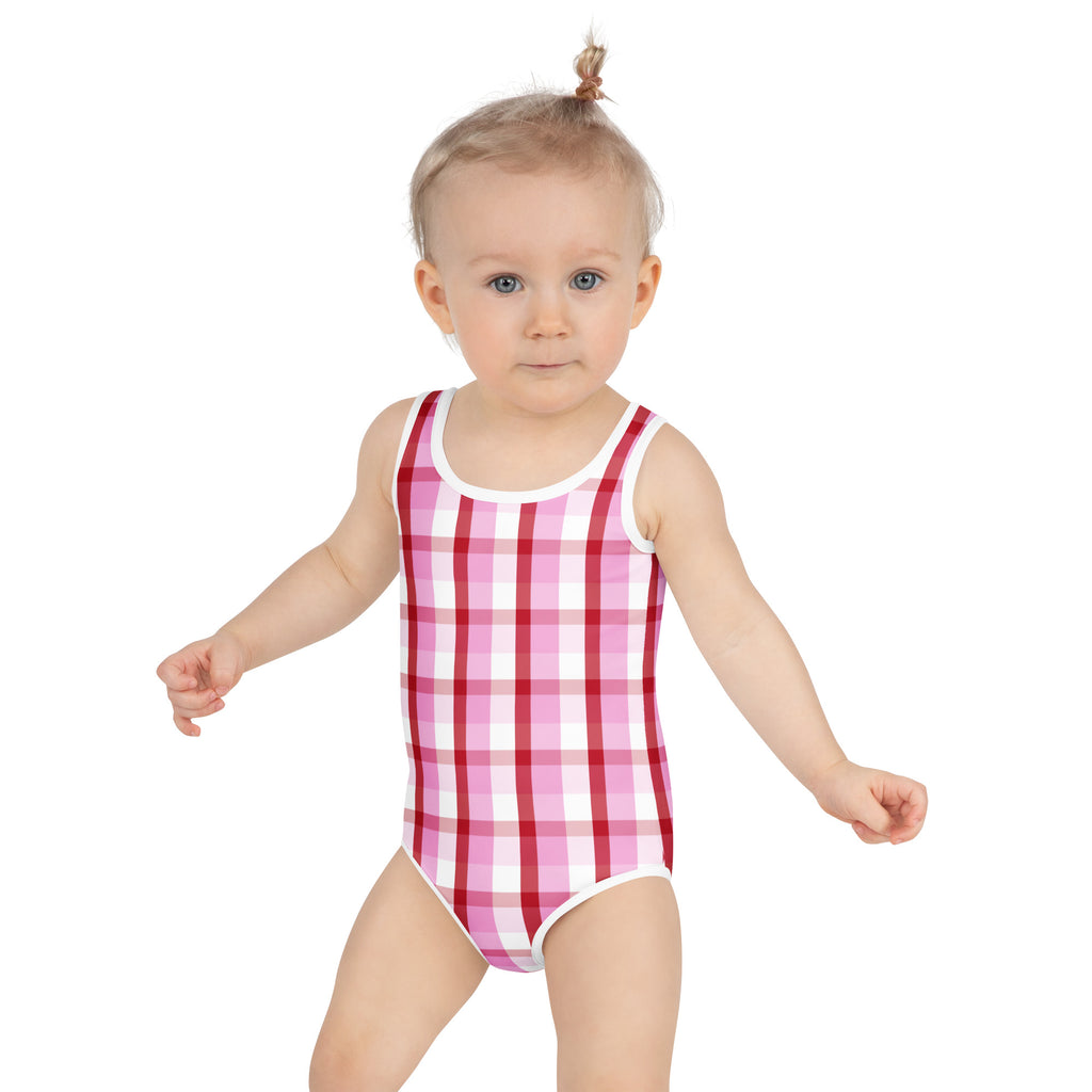 A toddler wearing a pink and white gingham buttery soft swimsuit with upf 50 plus and double layered front