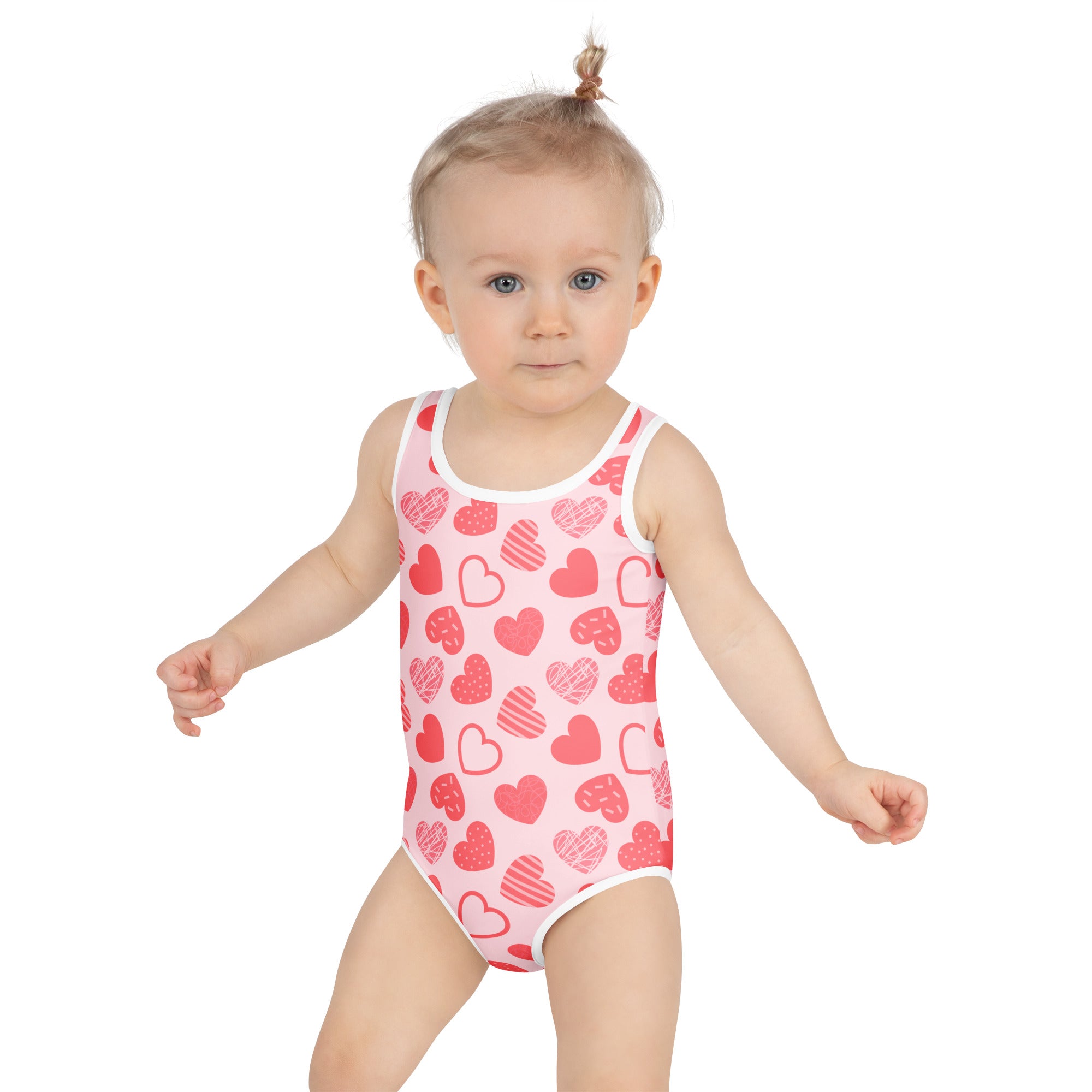 Girls pink heart pattern buttery soft swimsuit with white trim and upf 50 plus featuring red heart designs