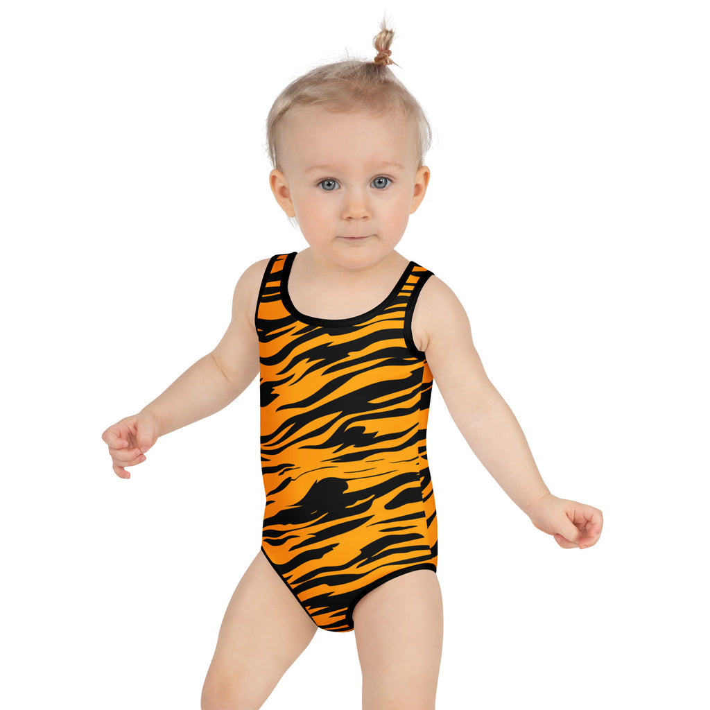 A toddler wearing a girls tiger stripe buttery soft swimsuit in orange and black with racerback and upf 50 plus protection