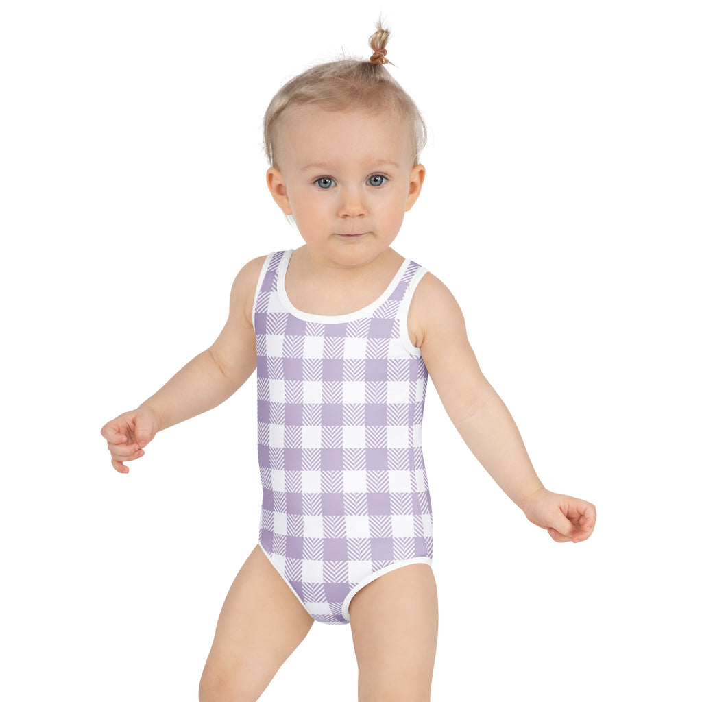 A toddler wearing a girls purple gingham buttery soft one-piece swimsuit with UPF 50 plus and double layered front