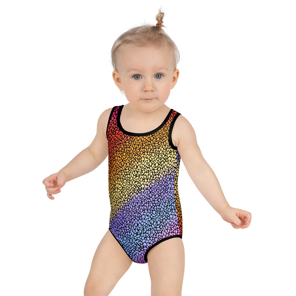 A toddler wearing a girls colorful leopard print buttery soft swimsuit with upf 50 plus and black trim