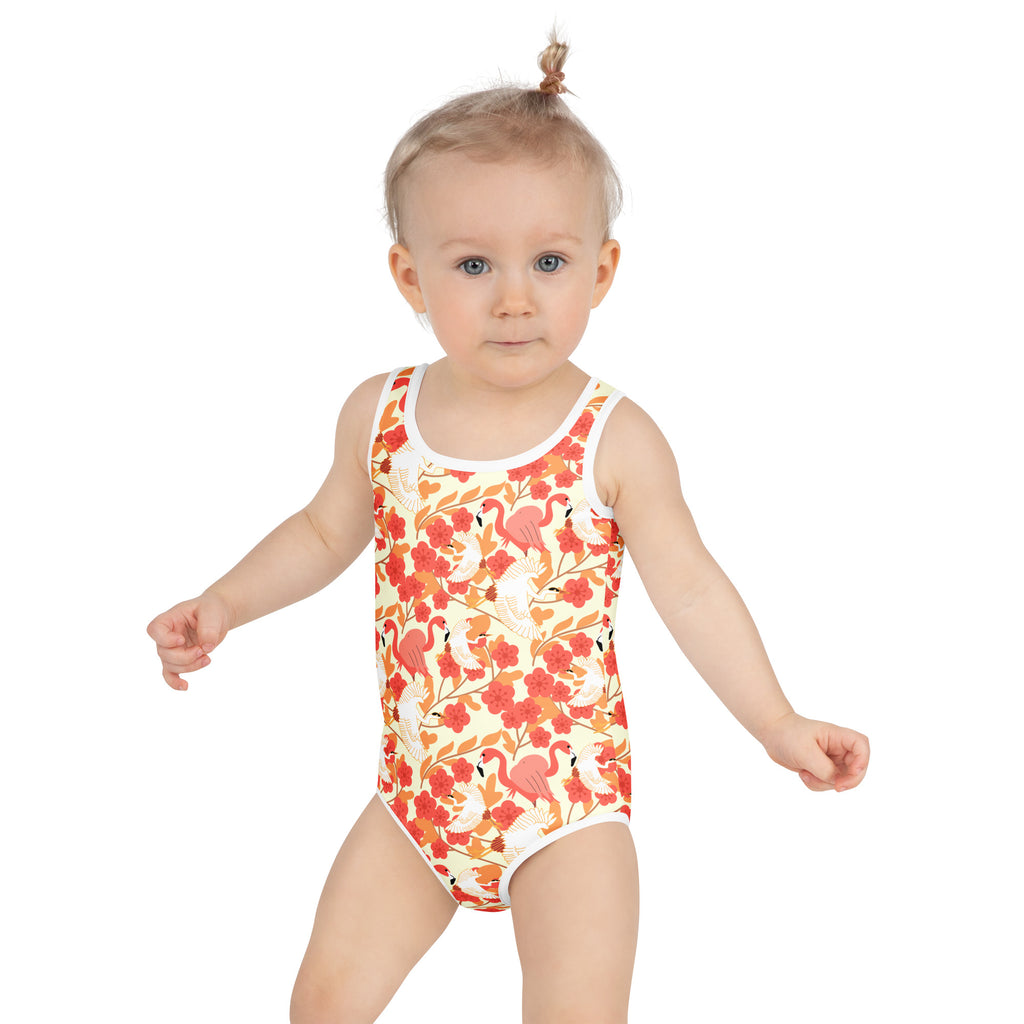 A child wearing a girls floral flamingo and pelican buttery soft swimsuit with UPF 50 and vibrant pink pattern