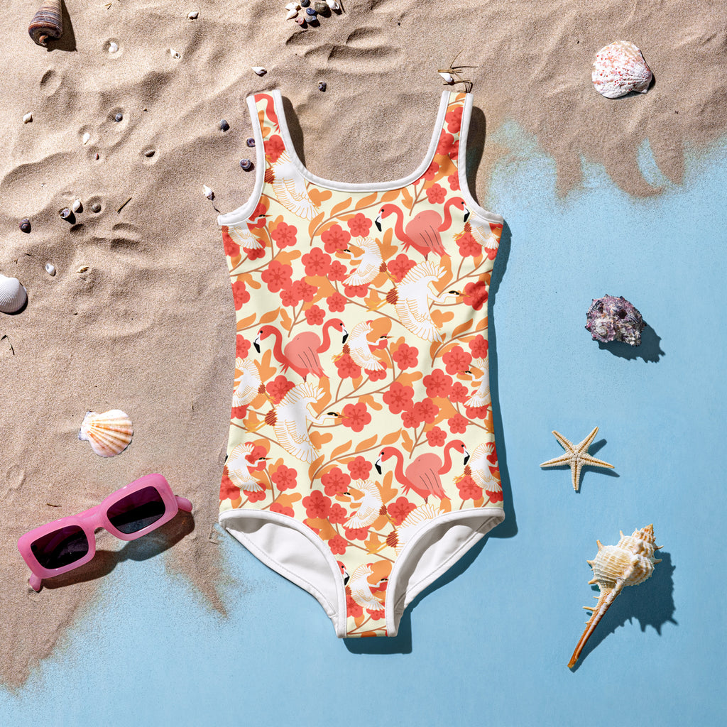 A vibrant coral and cream girls floral flamingo and pelican one-piece swimsuit with white trim and UPF 50 plus protection