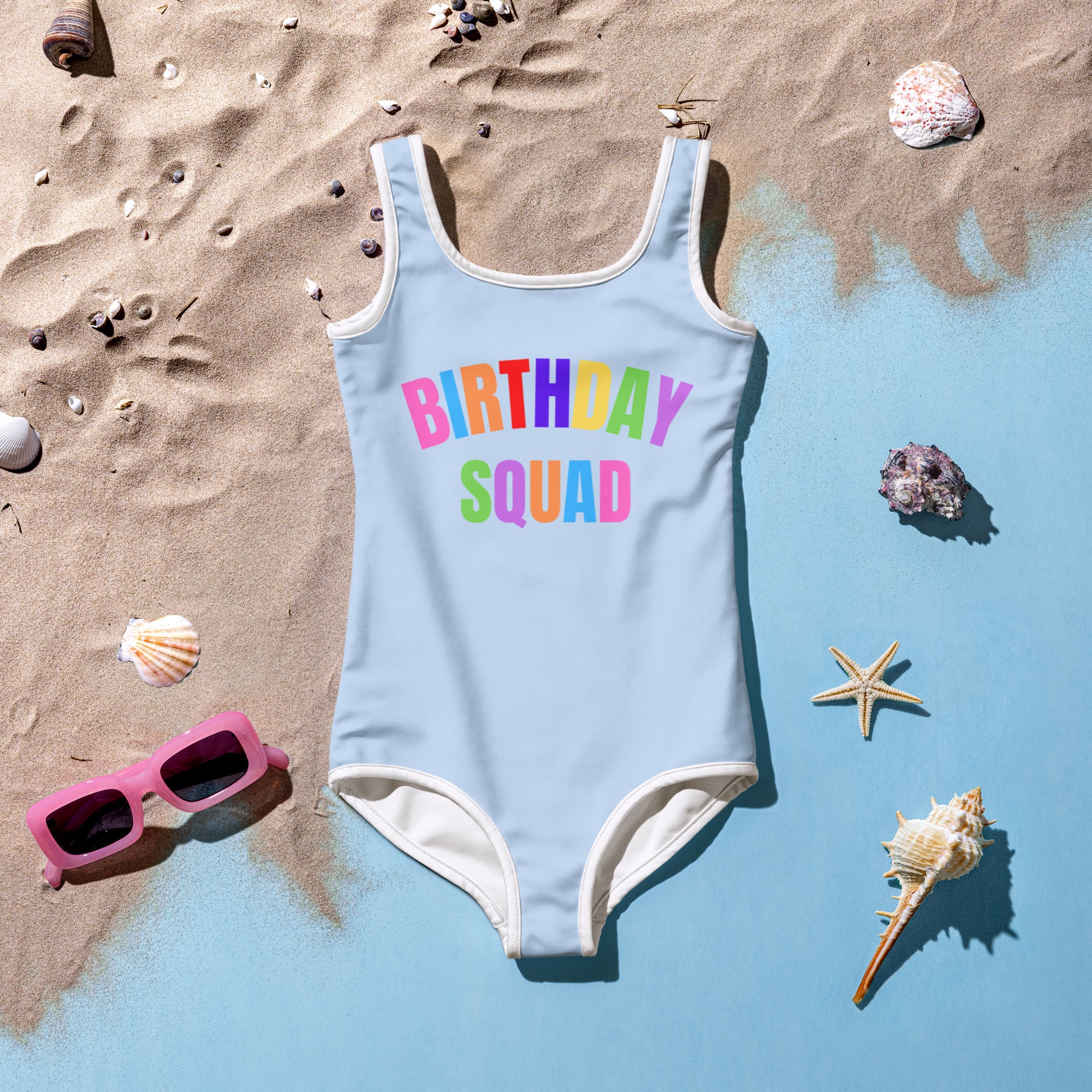 Light blue girls birthday squad buttery soft one-piece swimsuit with white trim and rainbow lettering UPF 50+ double layered front
