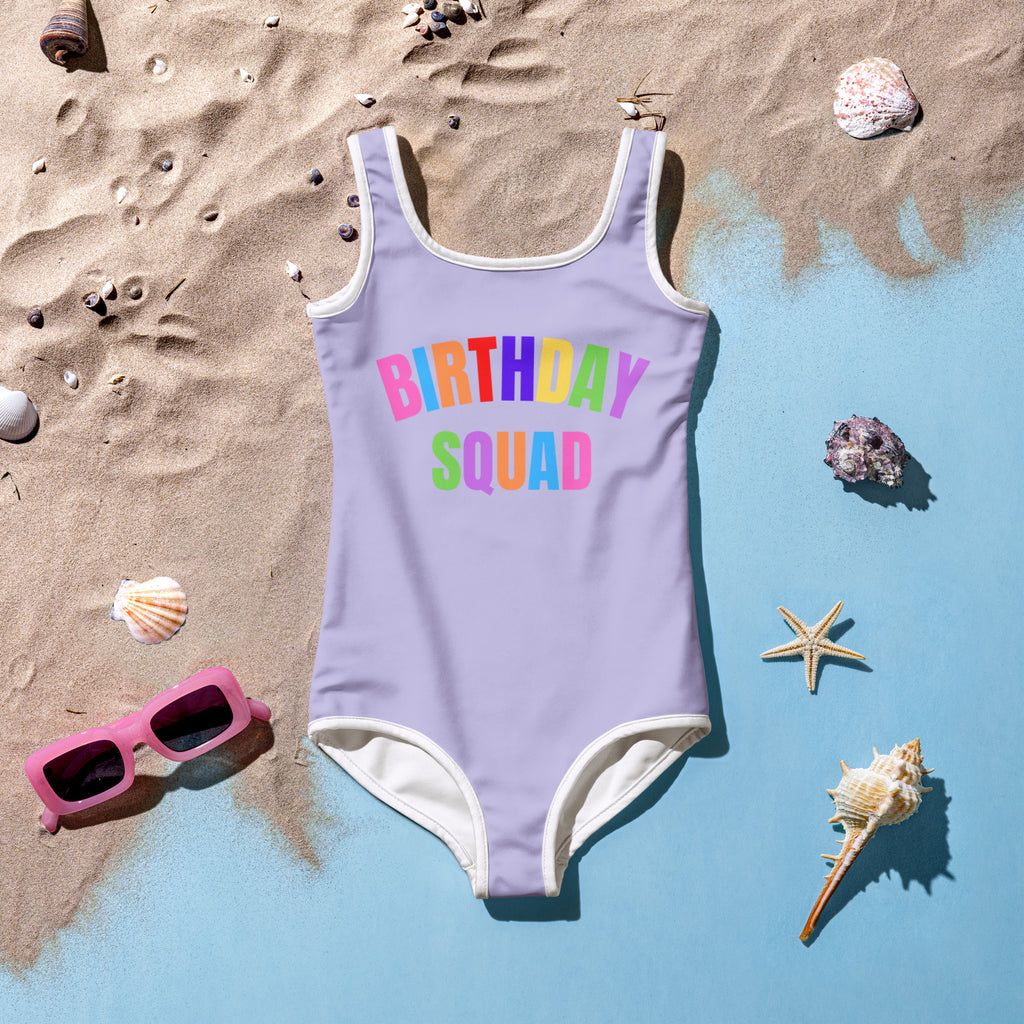 Girls birthday squad buttery soft lavender swimsuit with white trim colorful rainbow graphic upf 50 plus double layered front