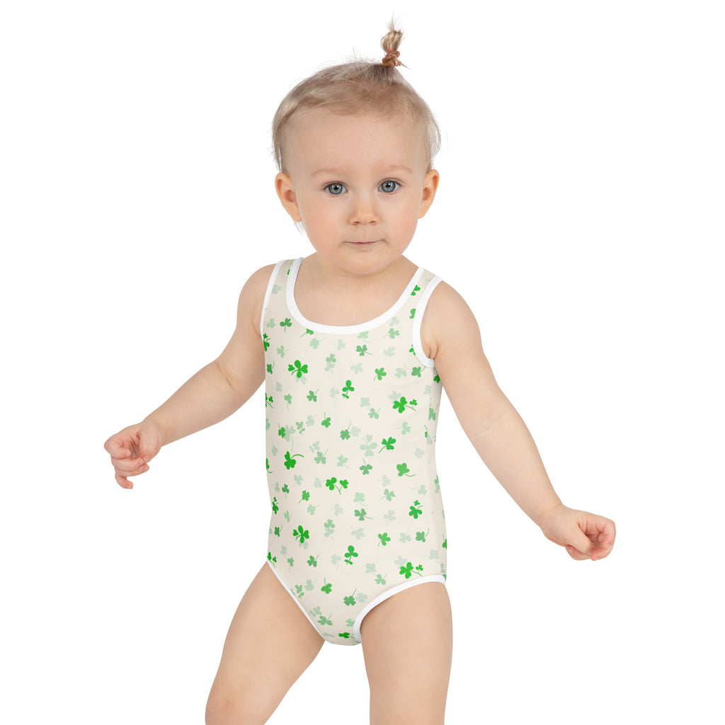 A child wearing a white one-piece girls soft green shamrock buttery soft swimsuit with UPF 50+ and double layered front