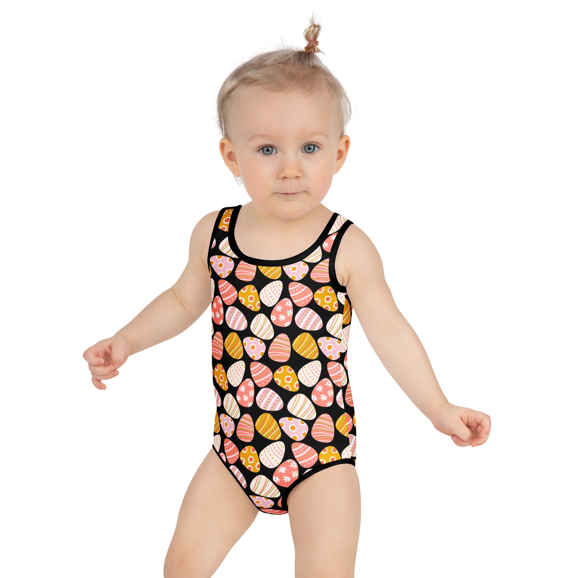 A toddler wearing a girls pink easter egg buttery soft black swimsuit with upf 50 and double layered front