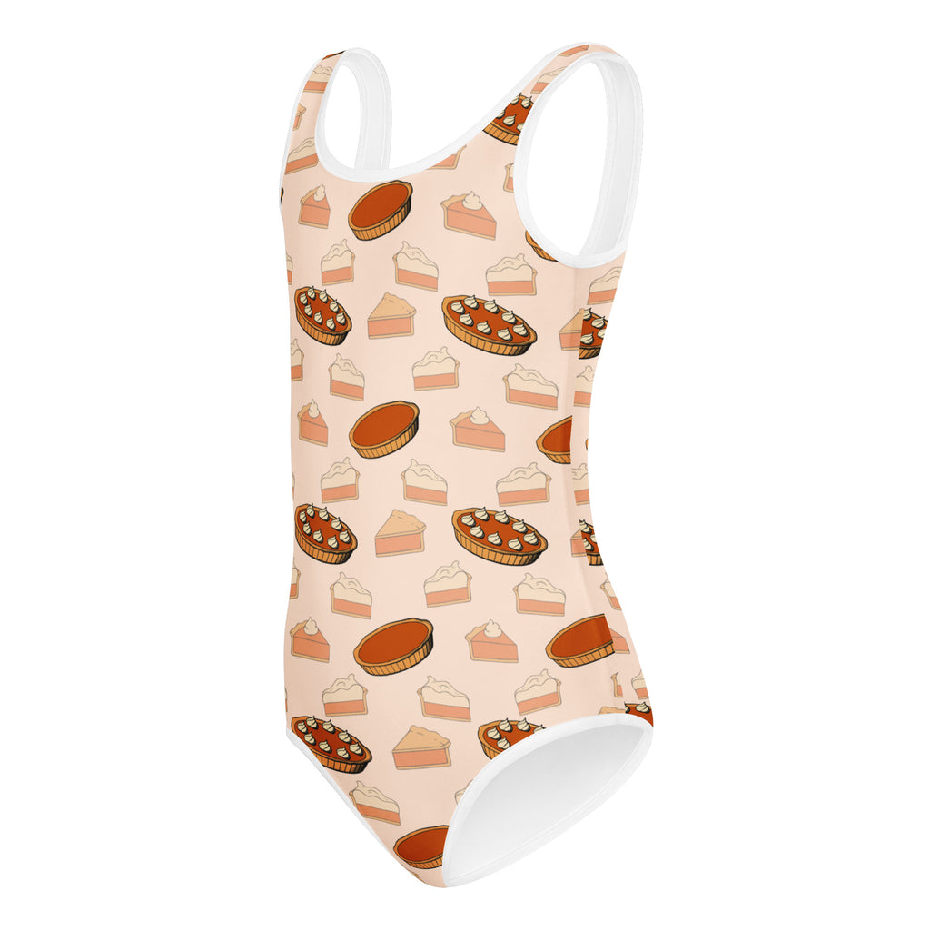 A peach-colored girls pumpkin pie thanksgiving leotard with white trim and pie illustrations for dance and gymnastics