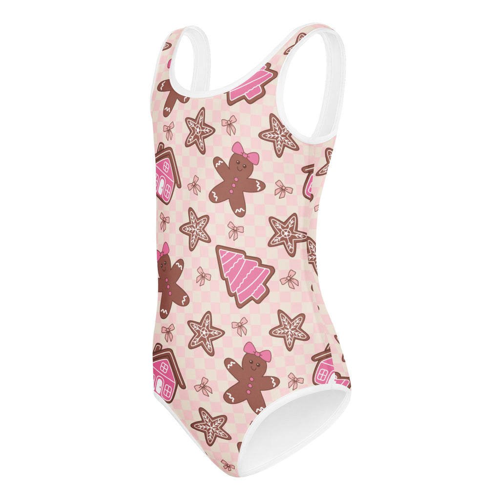 Girls pink gingerbread buttery soft one-piece swimsuit with white trim featuring festive cookie and tree pattern for dance and gymnastics