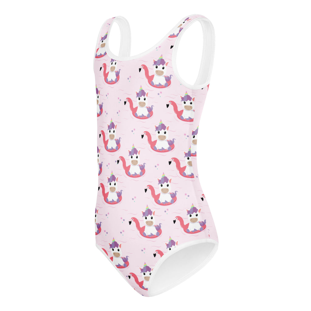 Pink one-piece swimsuit with white trim and playful cartoon unicorns riding flamingos for girls dance and gymnastics