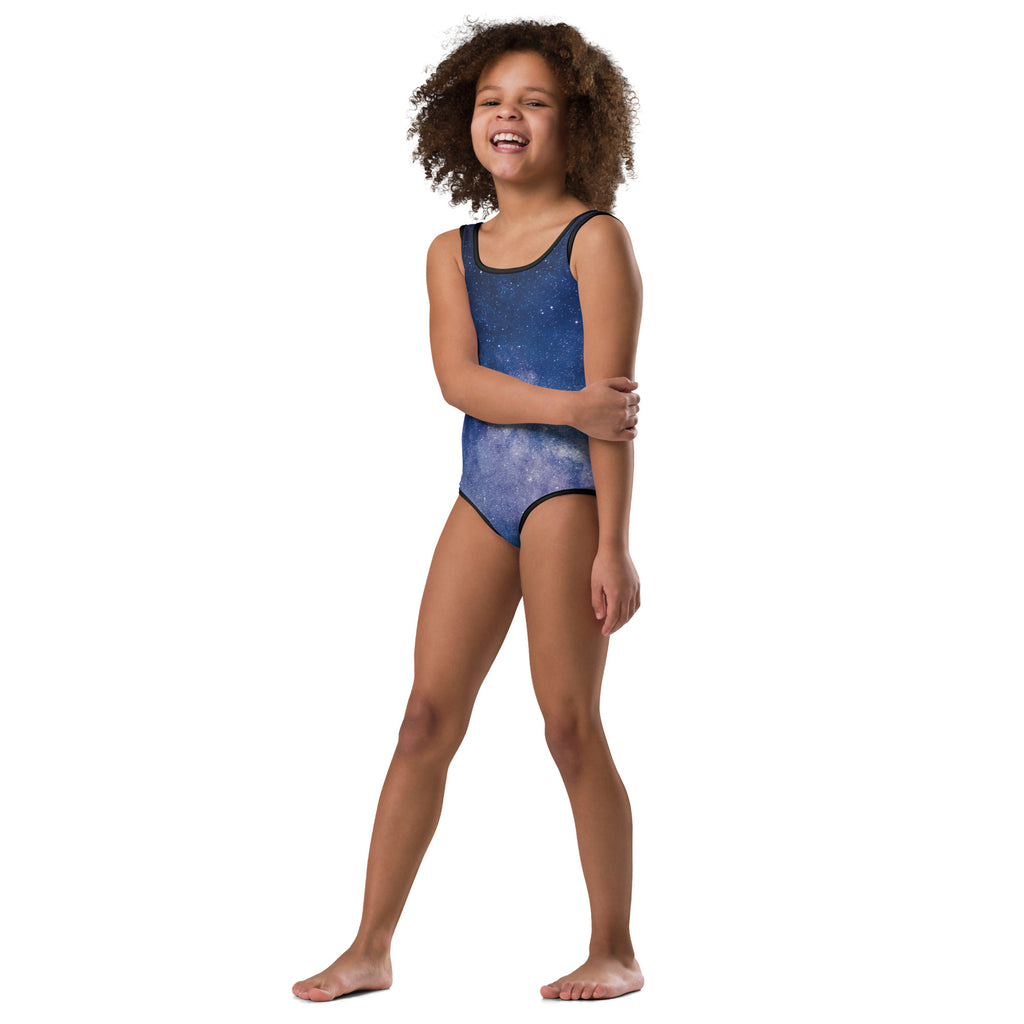 A child wearing a blue galaxy-themed buttery soft quick drying leotard with black trim for dance and gymnastics