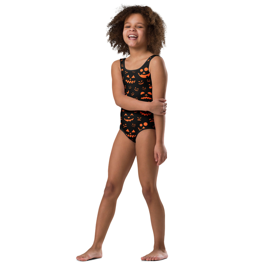 Black one-piece swimsuit with orange jack-o lantern faces and triangular accents for girls dance and gymnastics