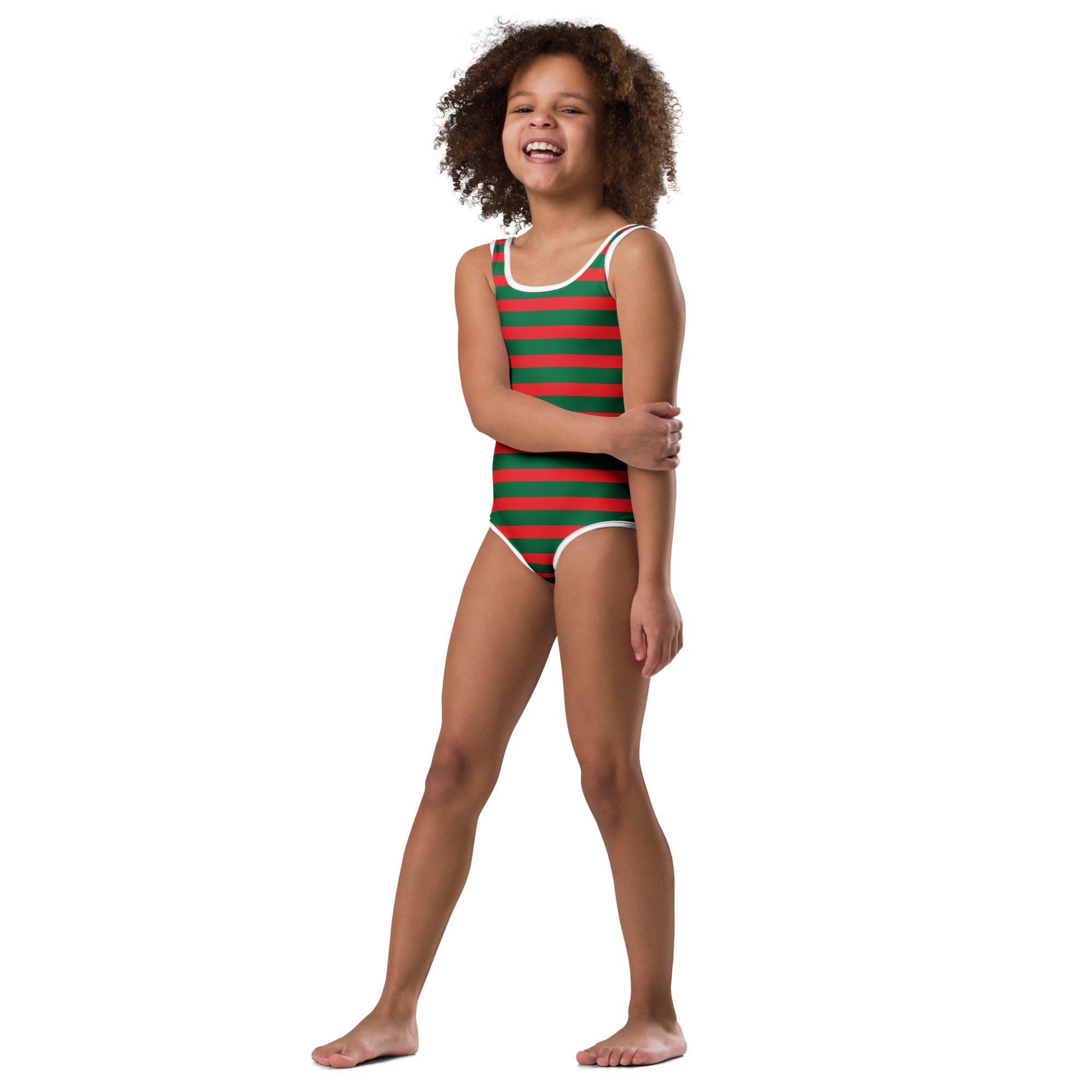 A cheerful young girl wearing a red and green striped buttery soft quick drying leotard for dance and gymnastics