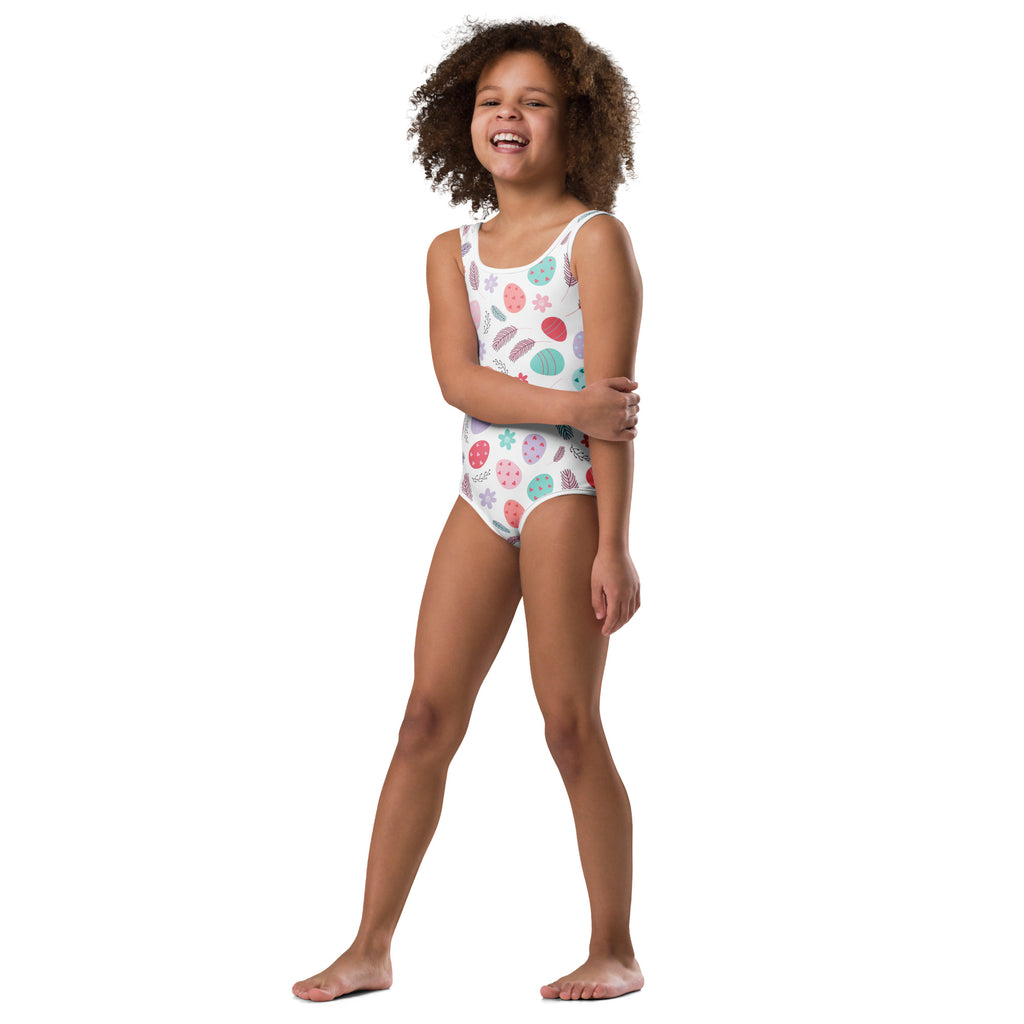 White one-piece swimsuit with colorful seashell and starfish pattern in pastel pink teal and green for girls