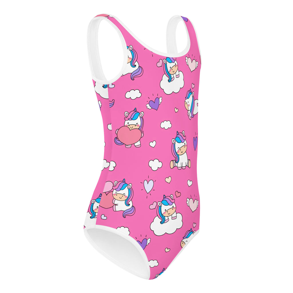 Pink kids swimsuit with cute unicorn and heart print, all-over cartoon pattern.