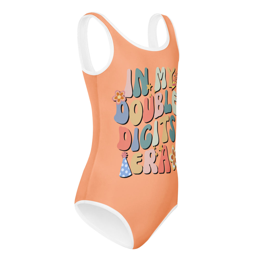 A vibrant orange girls leotard with white trim featuring an in my double digits era graphic quick drying for dance