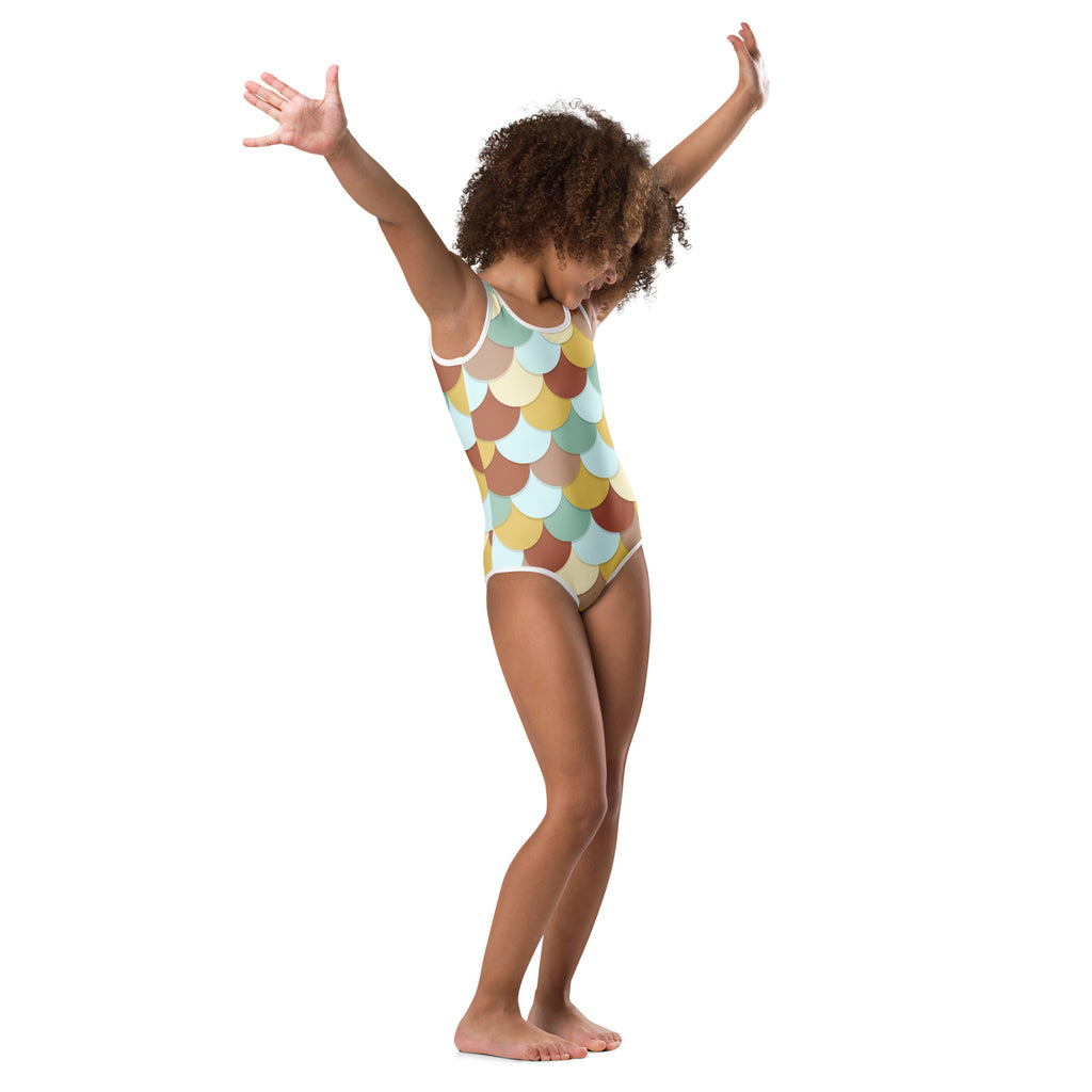 A child wearing a girls mermaid buttery soft quick drying leotard in pastel mint beige and brown scale patterns