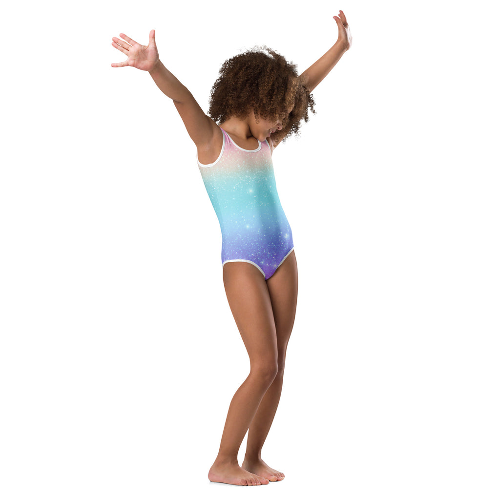A girl wearing a quick drying faux sparkle effect leotard with a pink blue purple galaxy print and white trim for dance