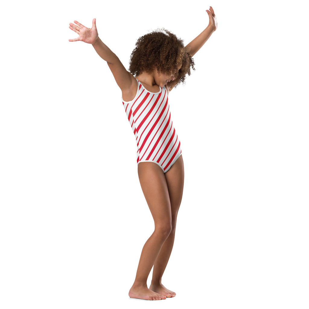 A young girl wearing a red and white candy cane stripe buttery soft leotard for dance and gymnastics