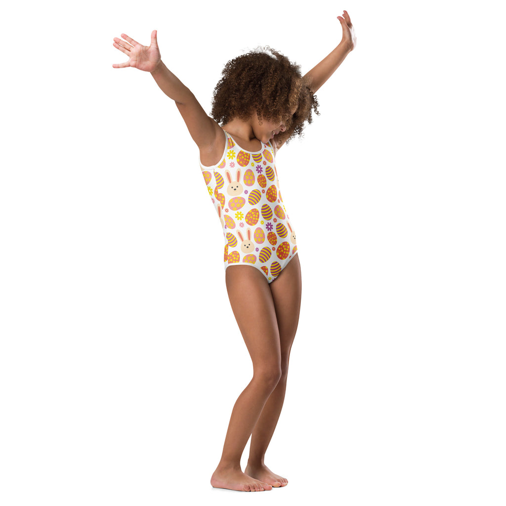 A white one-piece girls leotard with playful orange and brown easter eggs bunny faces and flowers quick drying gymwear
