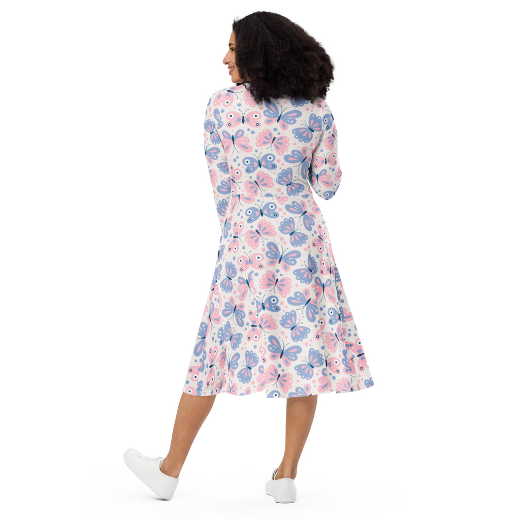 A woman wears a women’s pink and purple butterflies long sleeve midi dress with pockets in soft pink and lavender hues