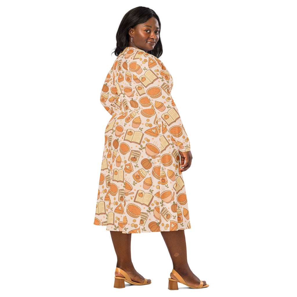 A plus-size woman wears a pumpkin pie themed long sleeve midi dress with pockets in cream with orange and beige prints
