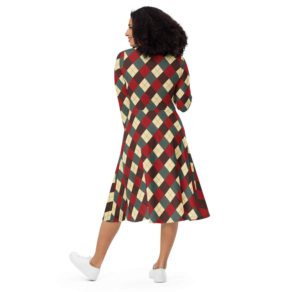 A woman wears a long-sleeved knee-length a-line midi dress with red dark green and cream argyle pattern and pockets