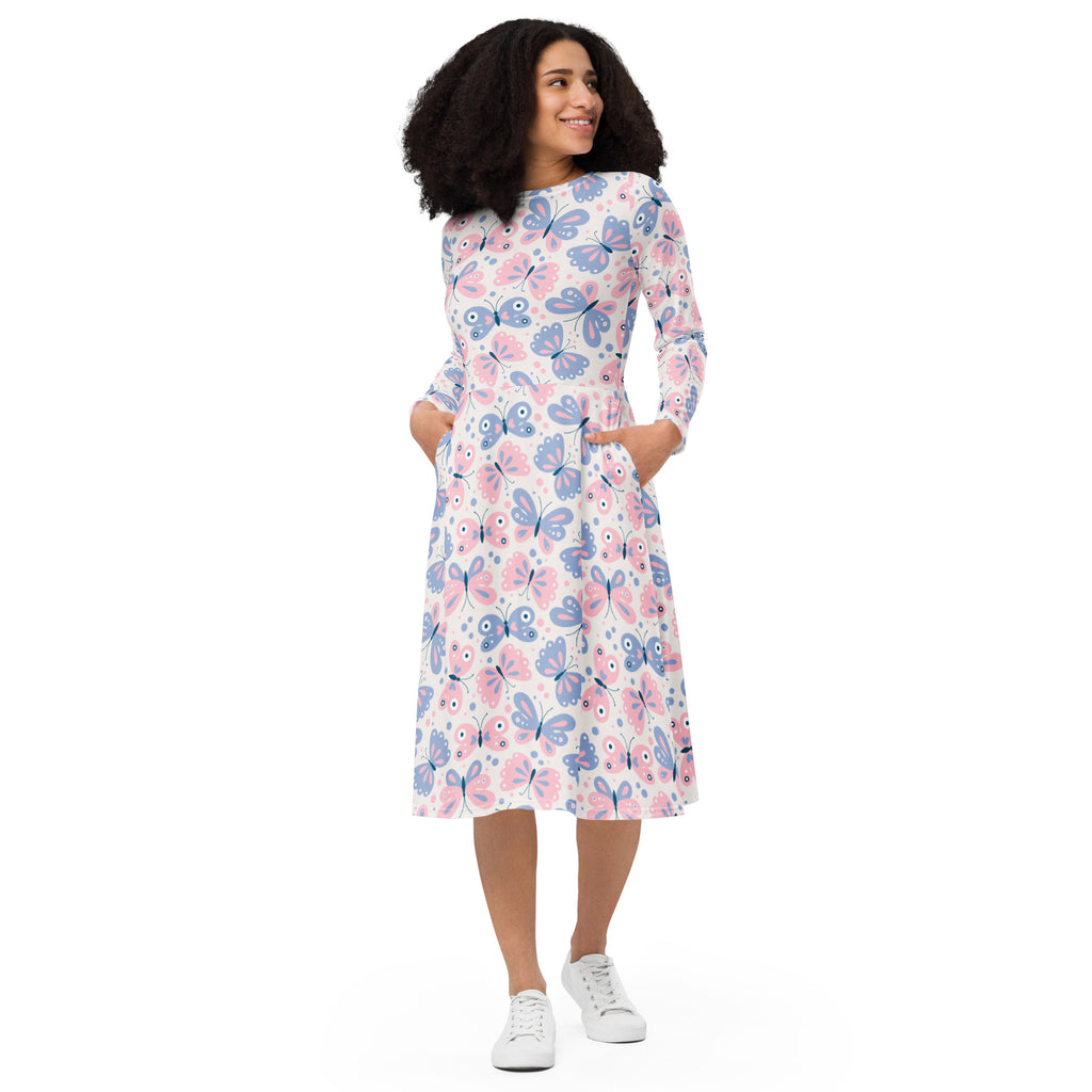 A woman wearing a white long sleeve midi dress with pink and purple butterfly pattern and pockets