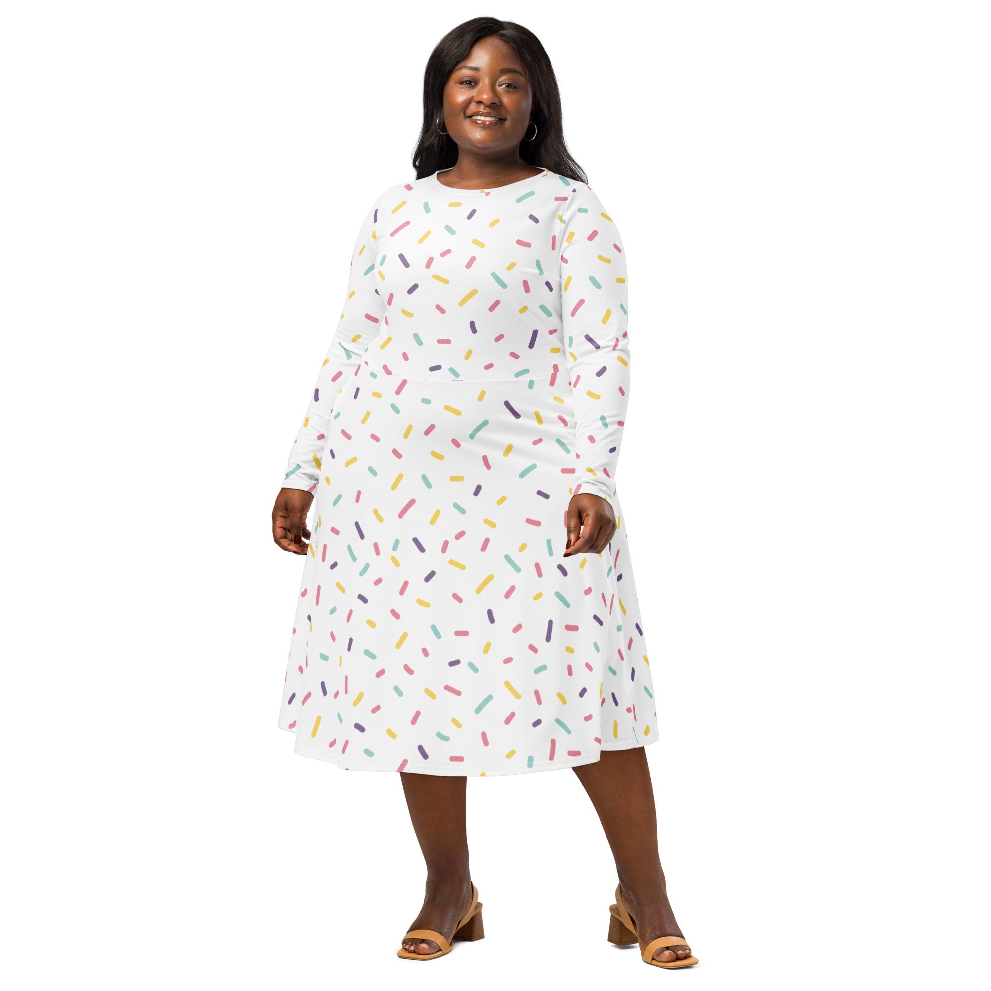 A plus-size woman wears a white long sleeve midi dress with colorful sprinkle patterns and pockets