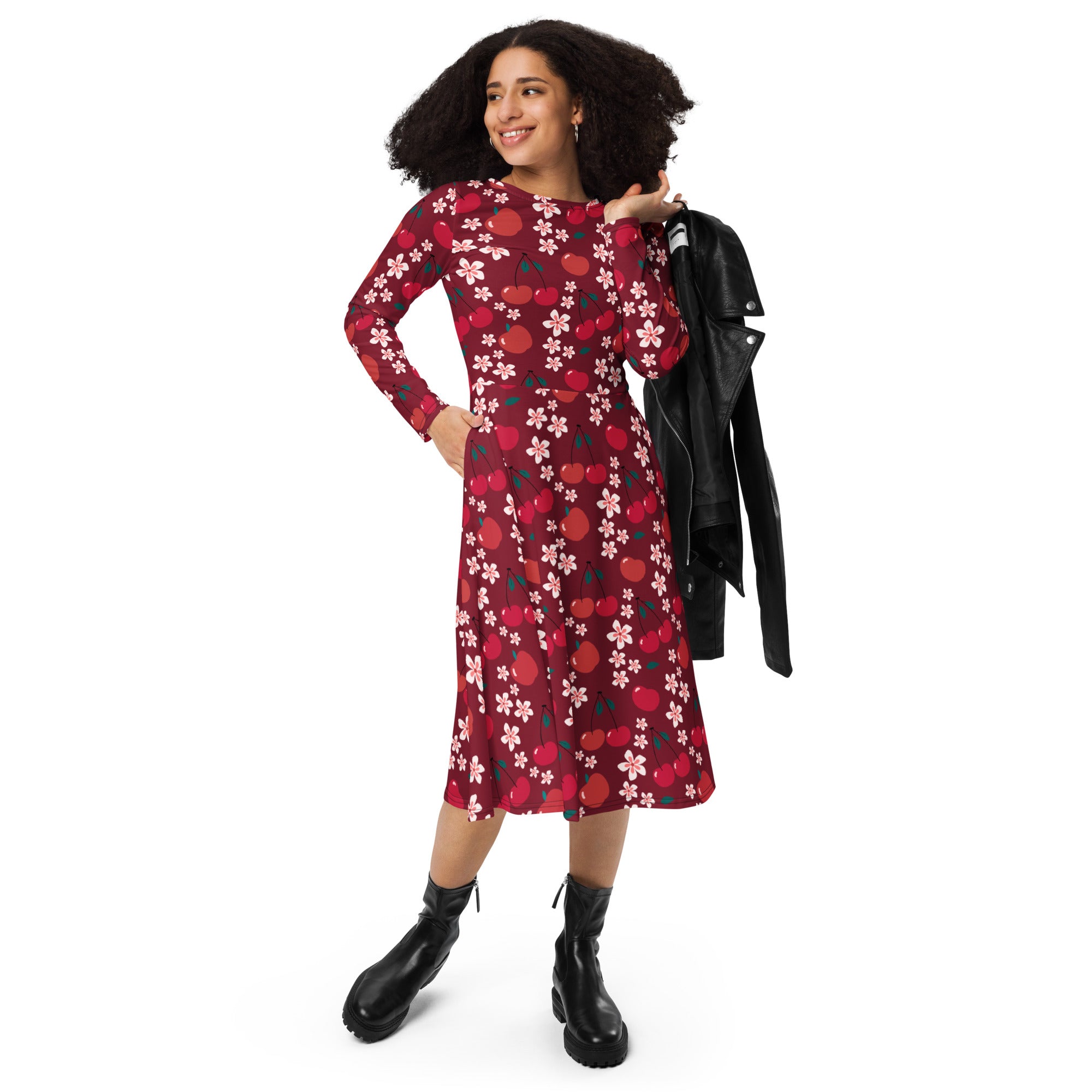 A woman wearing a deep red women’s cherry blossom long sleeve midi dress with pockets patterned with white flowers and orange cherries