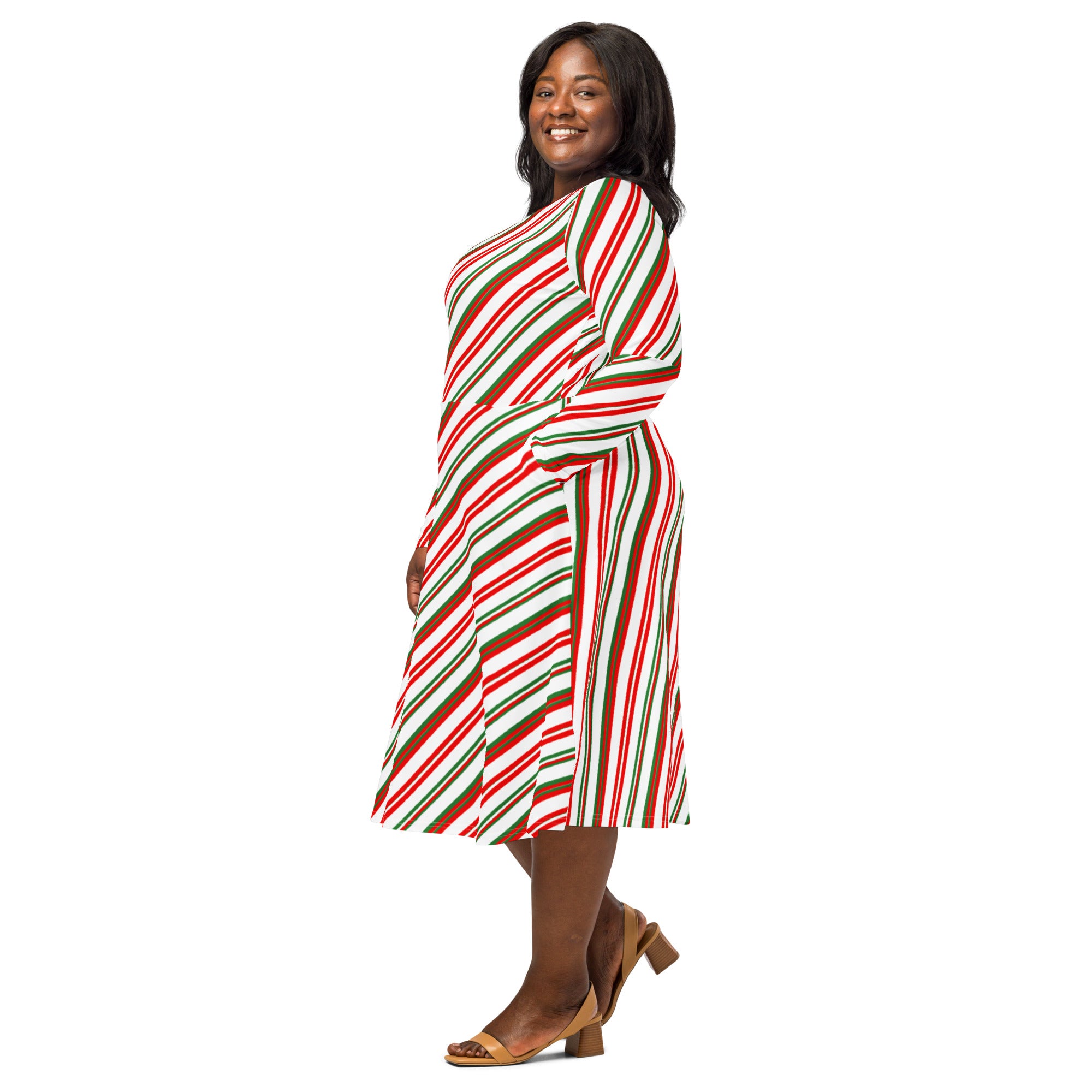 A plus-size woman wears a festive candy cane stripe long sleeve midi dress with pockets in red green and white