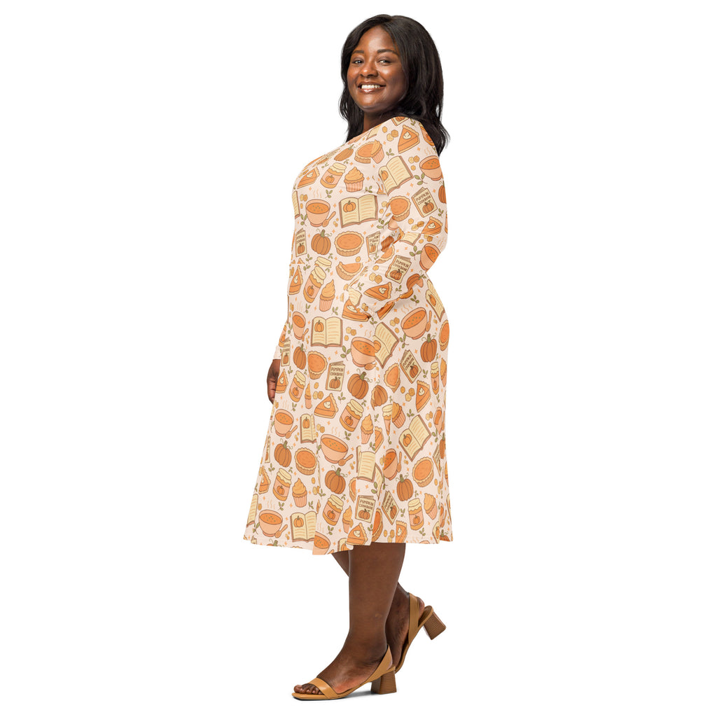 A plus-size woman wears a soft peach long sleeve midi dress with pumpkin pie themed pockets and playful pattern