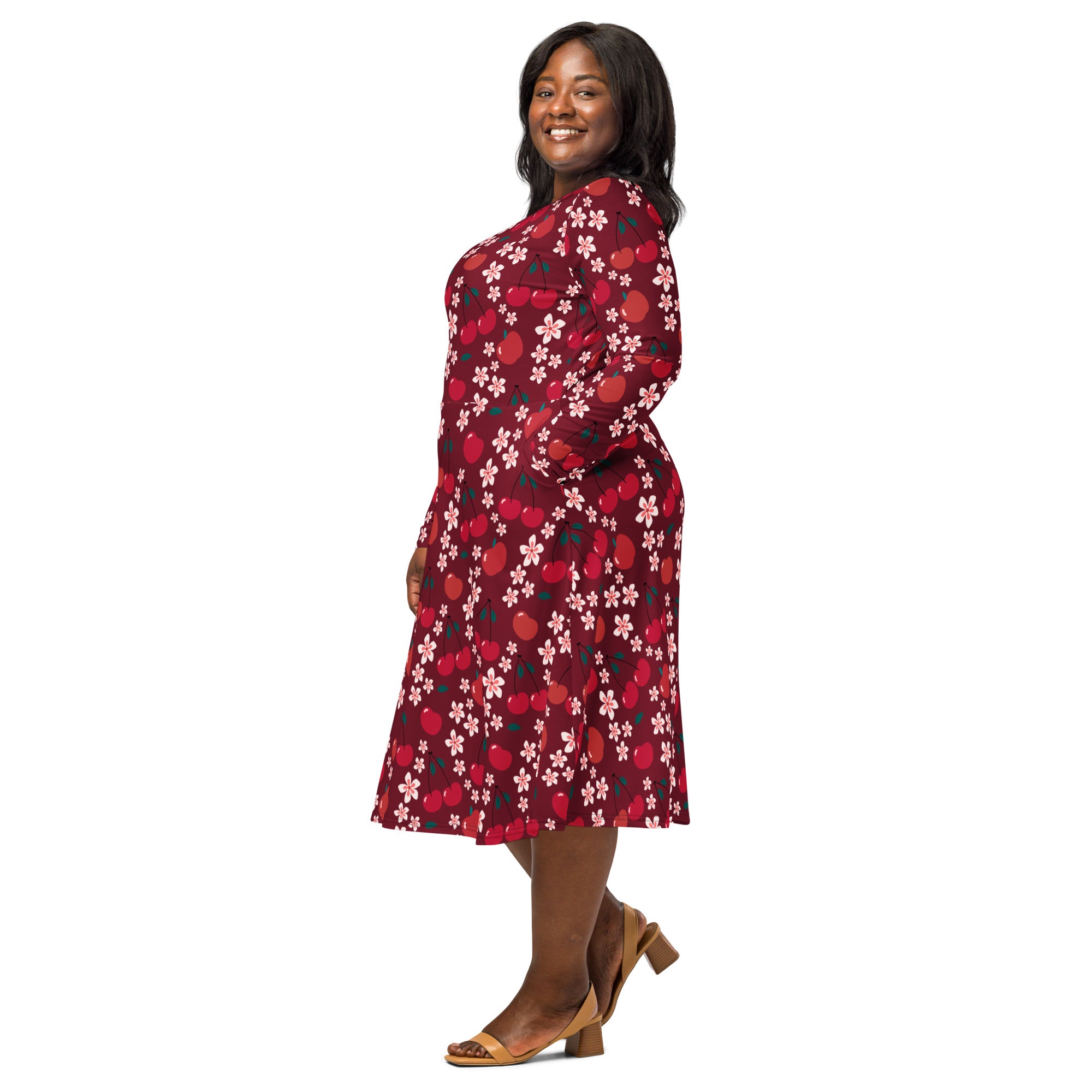 A plus-size woman wearing a maroon cherry blossom long sleeve midi dress with side pockets