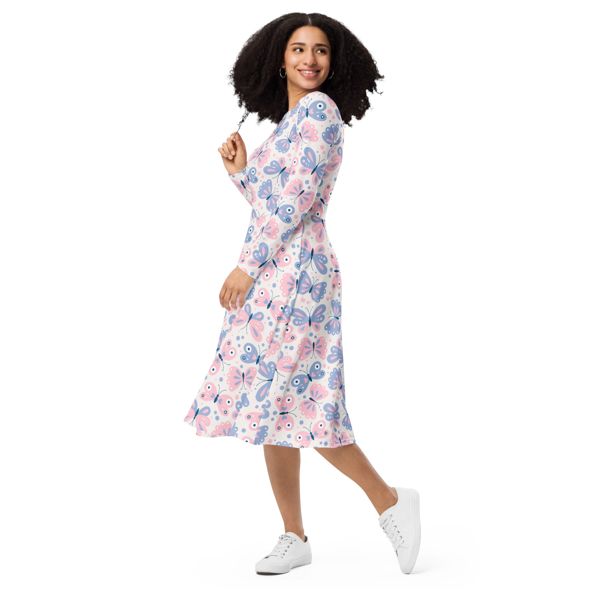 A woman wearing a women’s pink and purple butterflies long sleeve midi dress with pockets in soft hues on white background