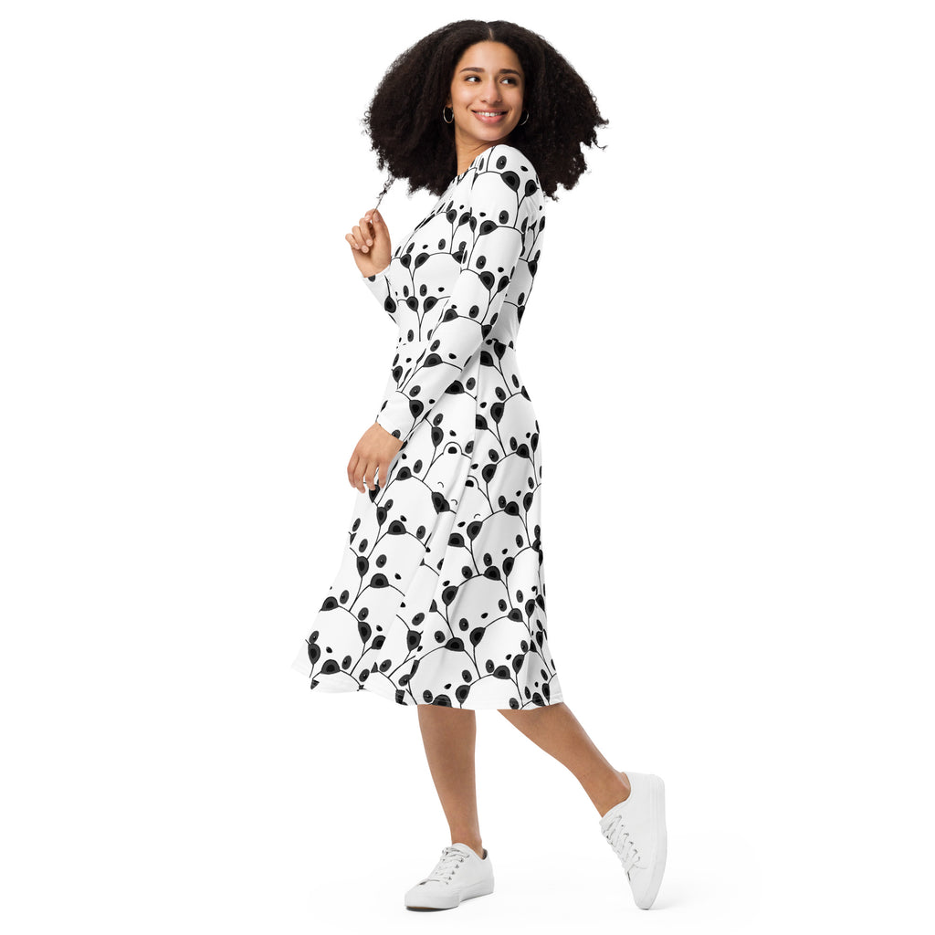 A woman wearing a white women’s panda long sleeve midi dress with black leafy vine patterns and pockets