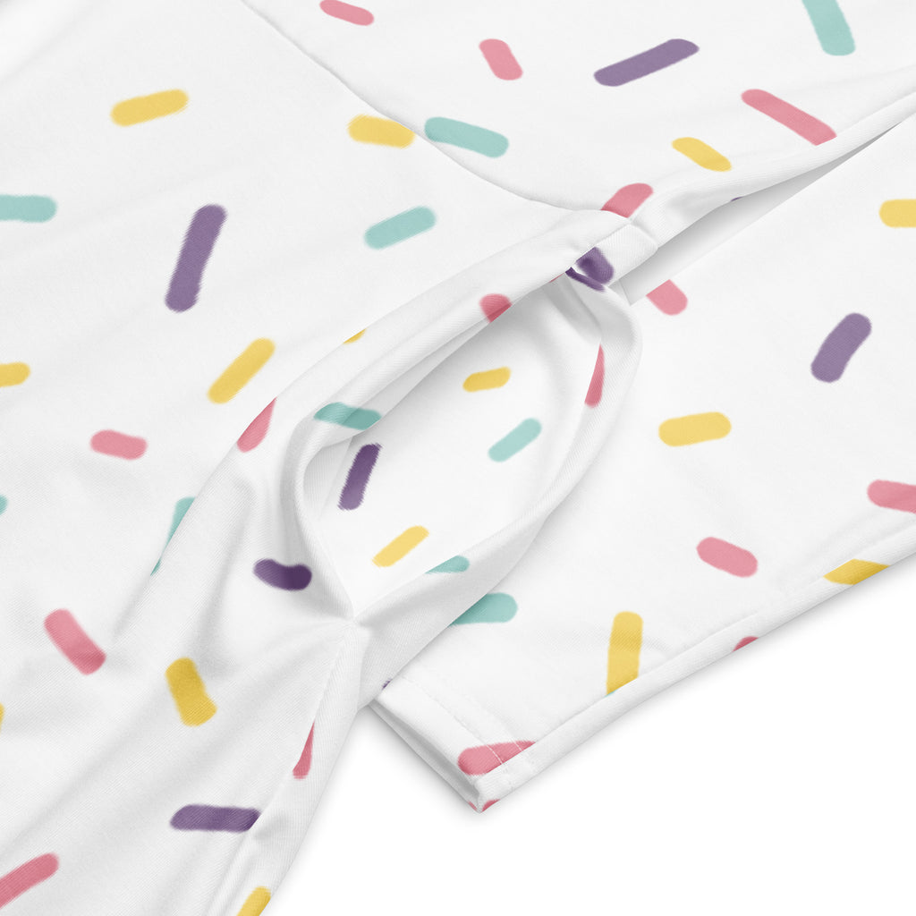 White fabric with colorful pastel sprinkles pattern on a women’s long sleeve midi dress with pockets