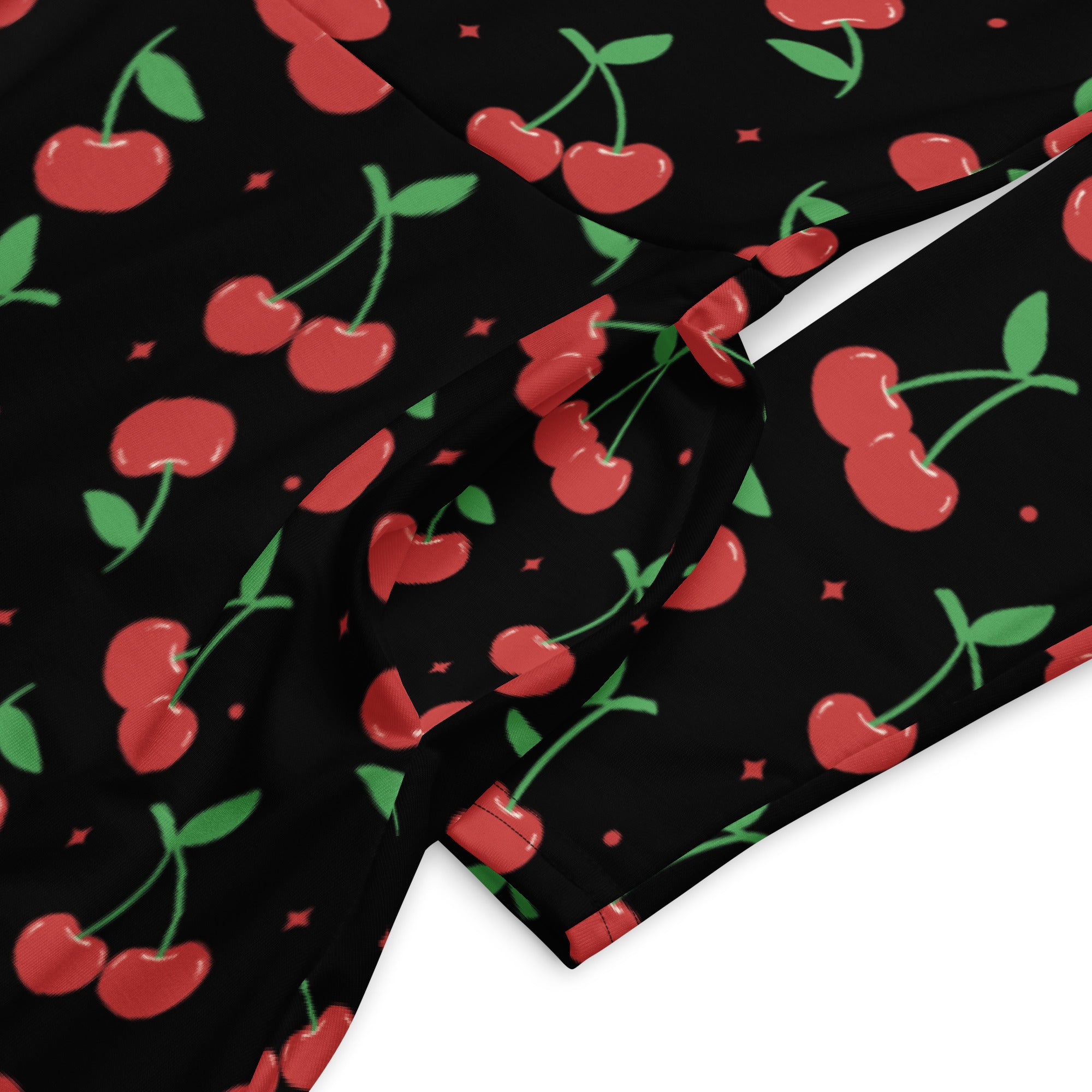 Black fabric of women’s cherry long sleeve midi dress with pockets featuring red cherries green stems and diamond details