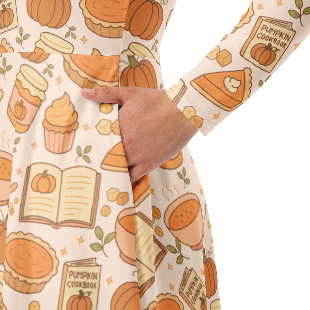 A cream-colored women’s long sleeve midi dress with pockets featuring a playful autumn pumpkin pie pattern