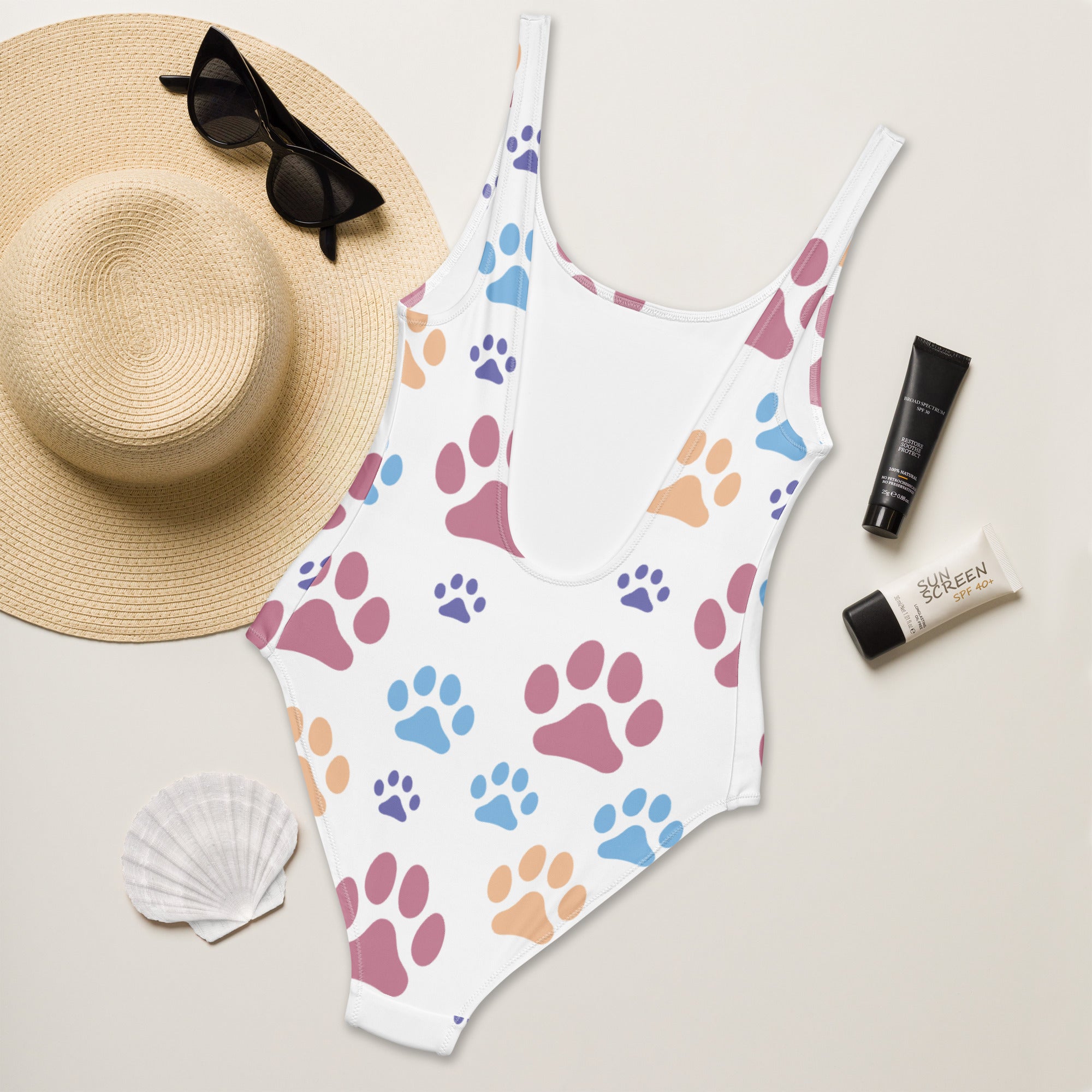 Women’s white one-piece buttery soft swimsuit with colorful paw prints in pink blue purple and upf 50 plus protection