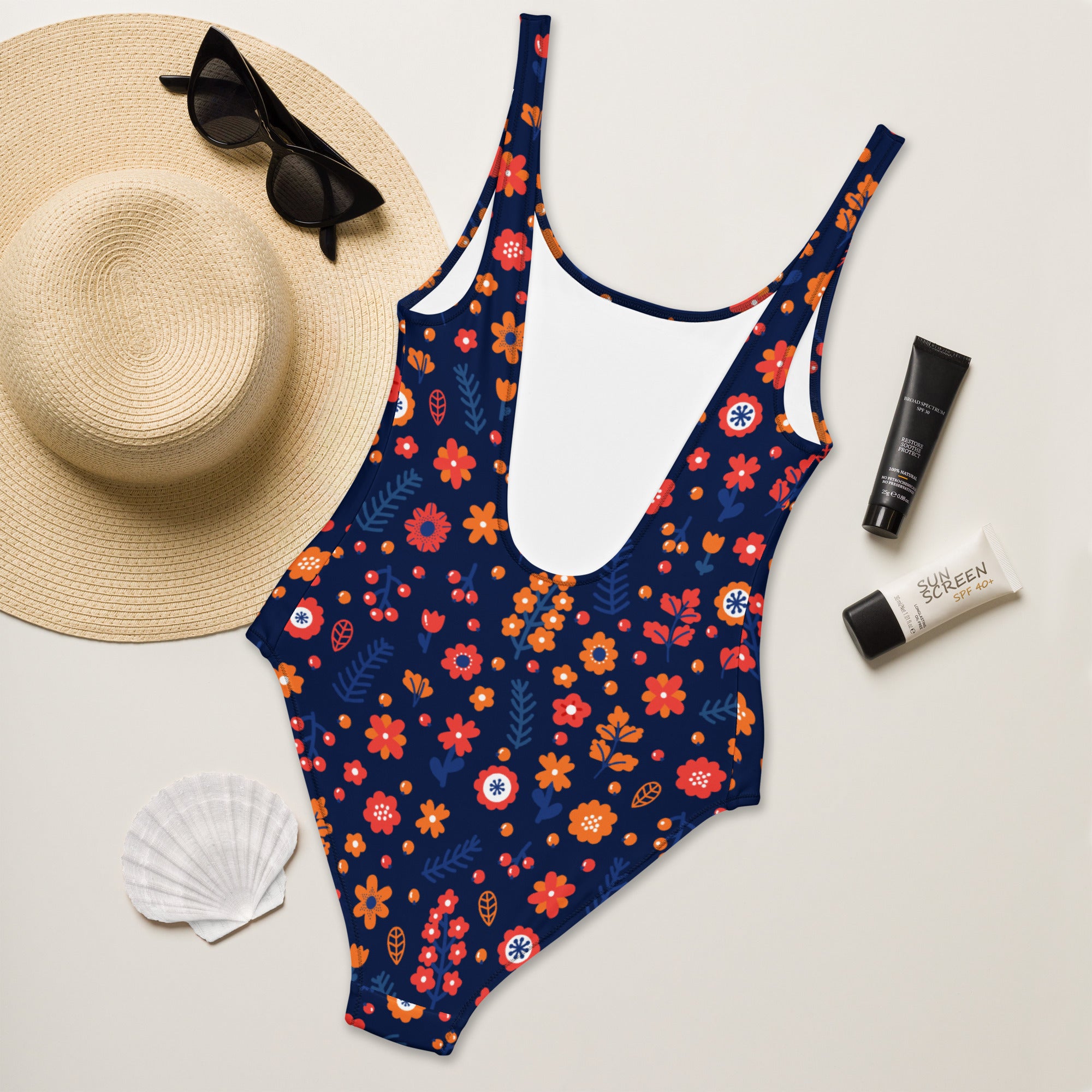 A navy blue one-piece women’s swimsuit with vibrant orange red white floral pattern made from buttery soft fabric with UPF 50+