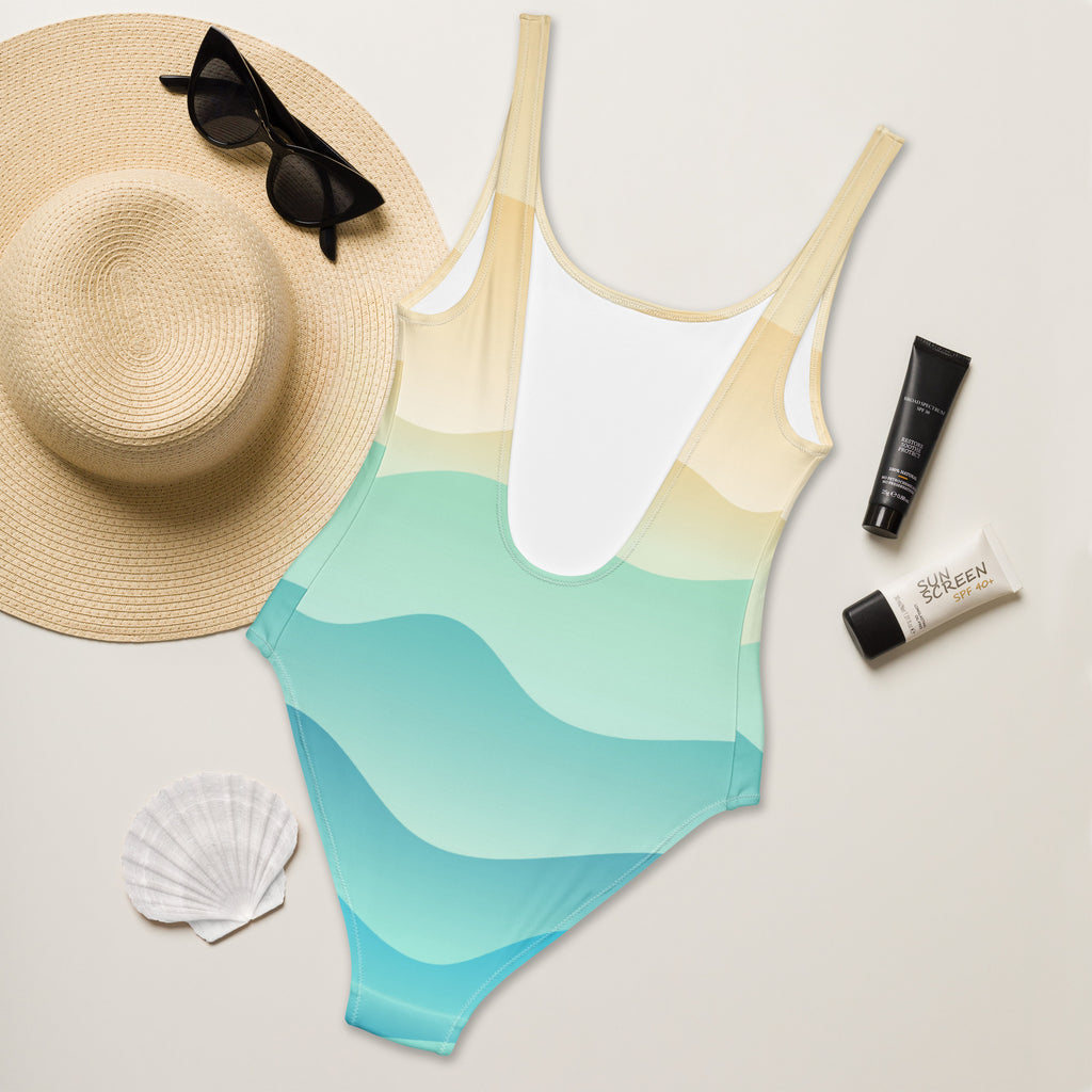 Women’s sandy ocean wave gradient buttery soft one-piece swimsuit with upf 50+ in beige to light blue with wavy patterns