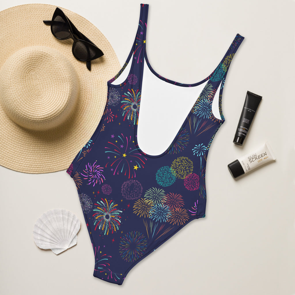 A navy blue women’s one-piece swimsuit with vibrant multicolored fireworks pattern and buttery soft fabric with UPF 50+ protection