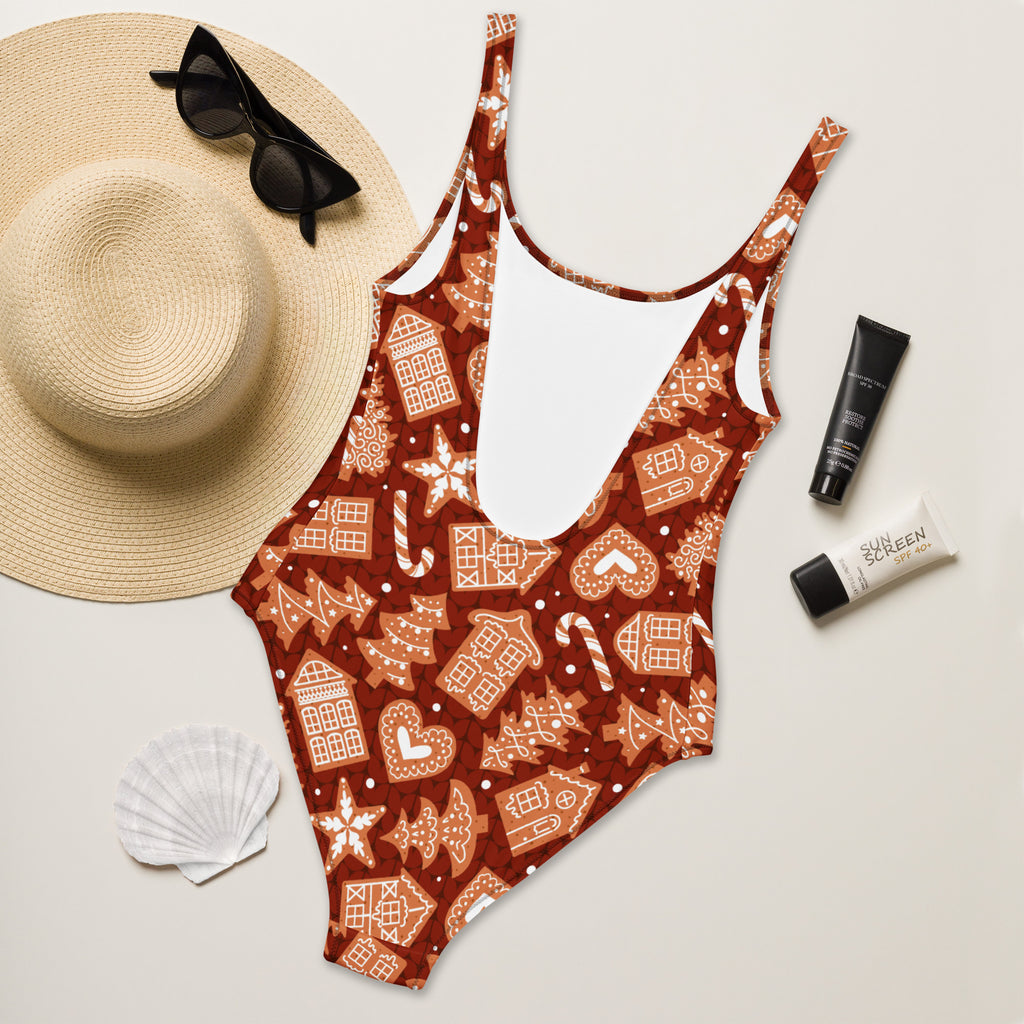 Women’s red gingerbread Christmas one-piece swimsuit in rich brown buttery soft fabric with white icing details and UPF 50+