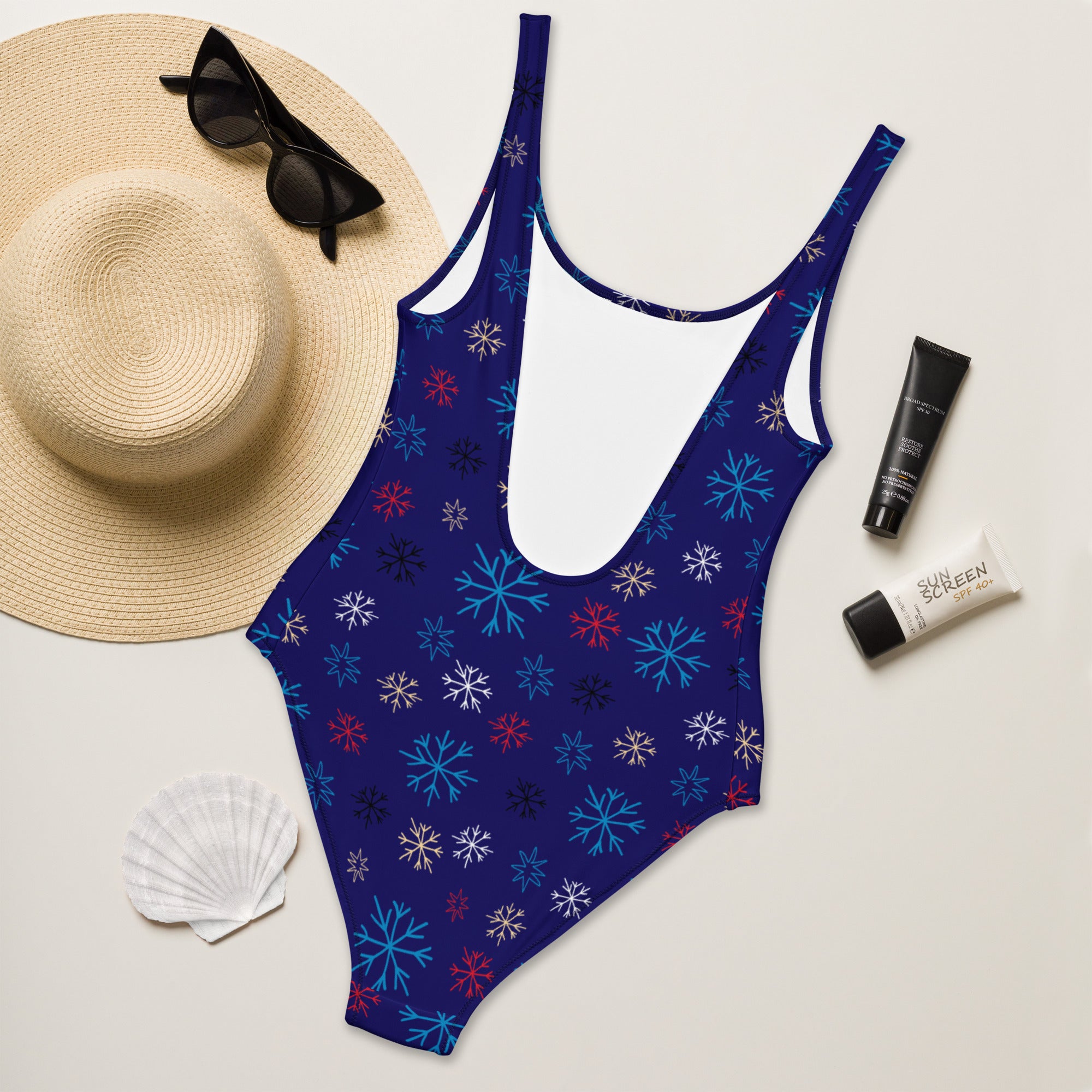 Women’s navy blue buttery soft one-piece swimsuit with vibrant snowflake pattern and upf 50 plus sun protection