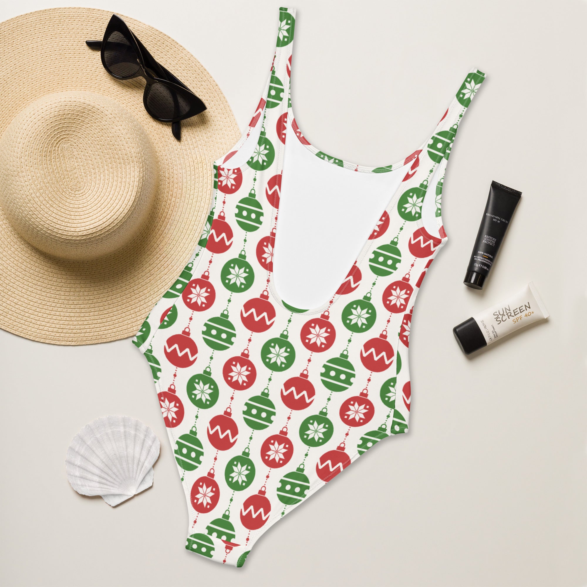 Festive women’s white one-piece swimsuit with red and green christmas ornament patterns and buttery soft fabric with UPF 50+