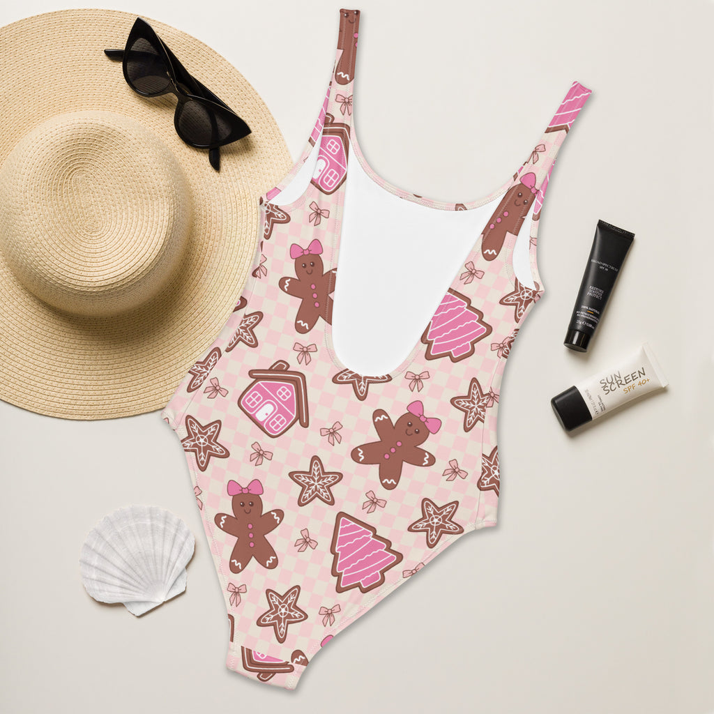 Women’s pink buttery soft one-piece swimsuit with gingerbread men pattern and UPF 50 plus sun protection