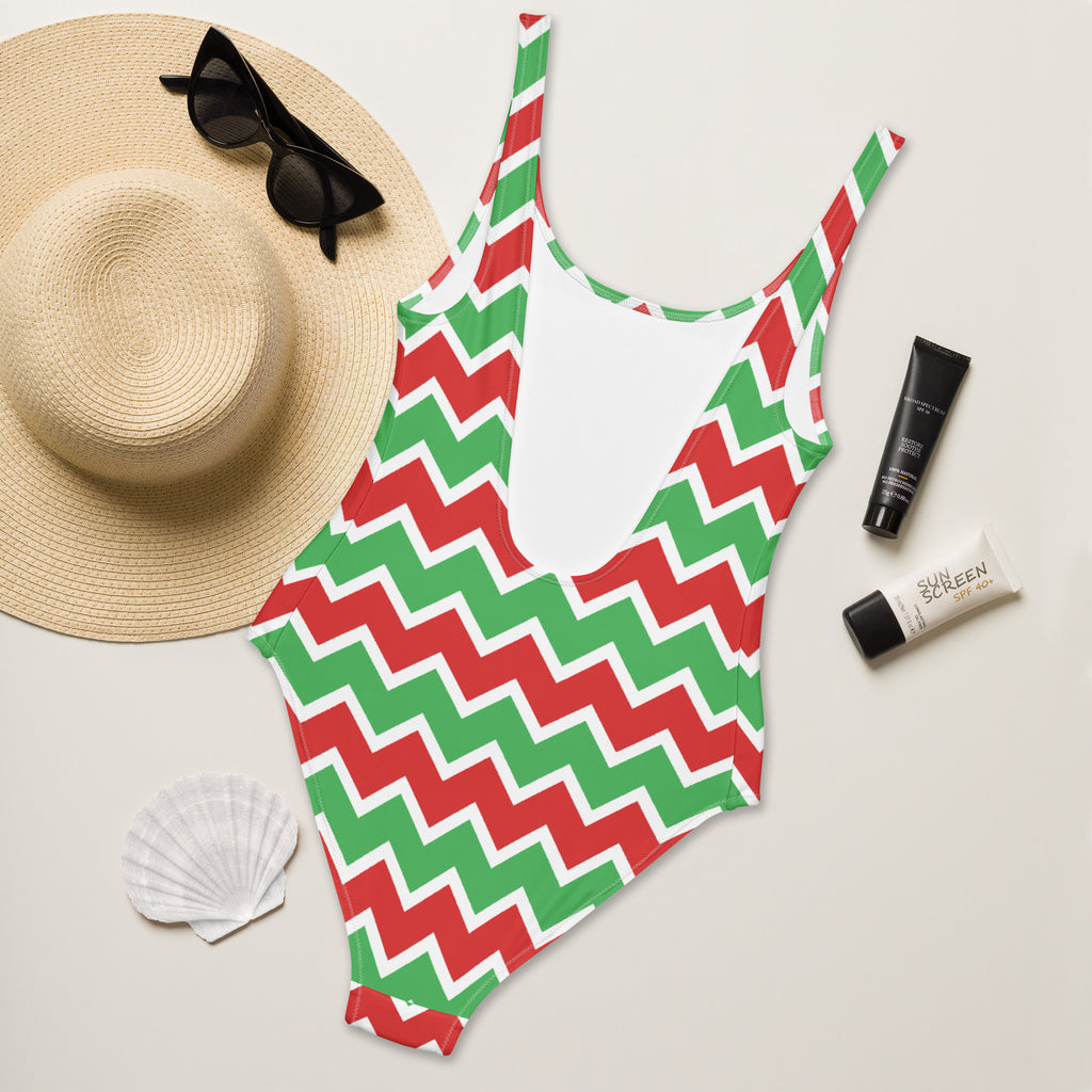 A vibrant red and green zigzag patterned women’s christmas chevron buttery soft swimsuit with white back panel and UPF 50+