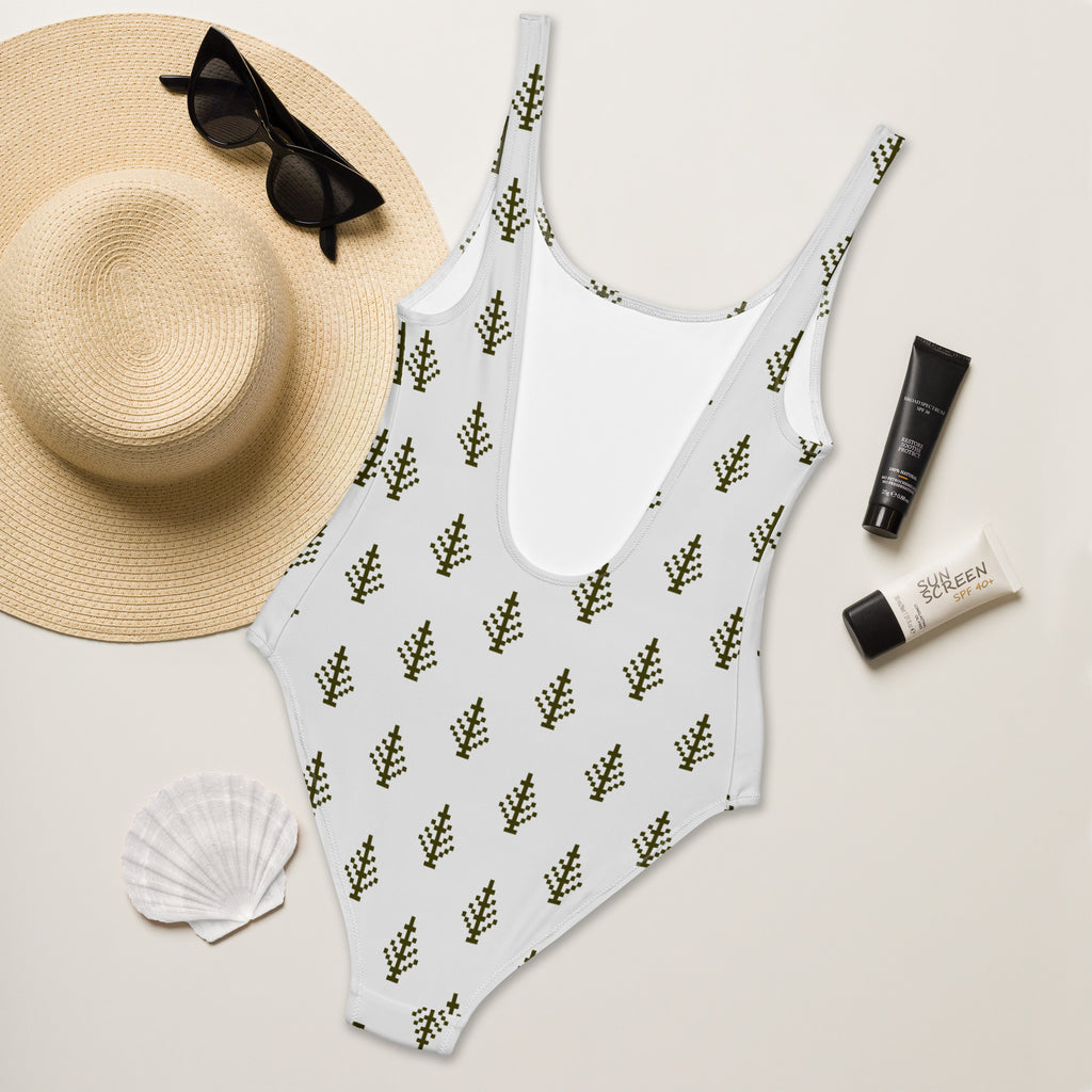 White one-piece swimsuit with dark green pixelated tree pattern and buttery soft fabric with upf 50 plus protection