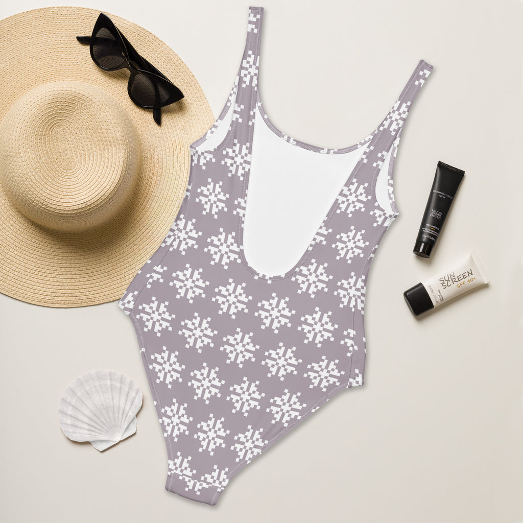 Women’s mauve buttery soft one-piece swimsuit with white pixel snowflake pattern and deep back cutout with UPF 50+